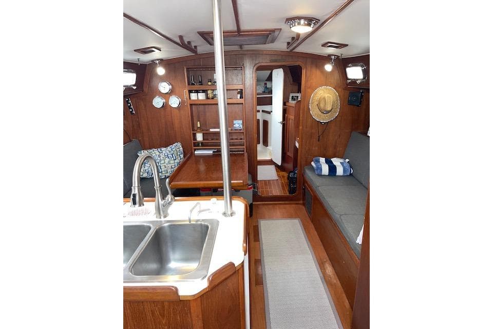 Interior of 1989 Caliber 38 sailboat with wood finish and cozy seating area.