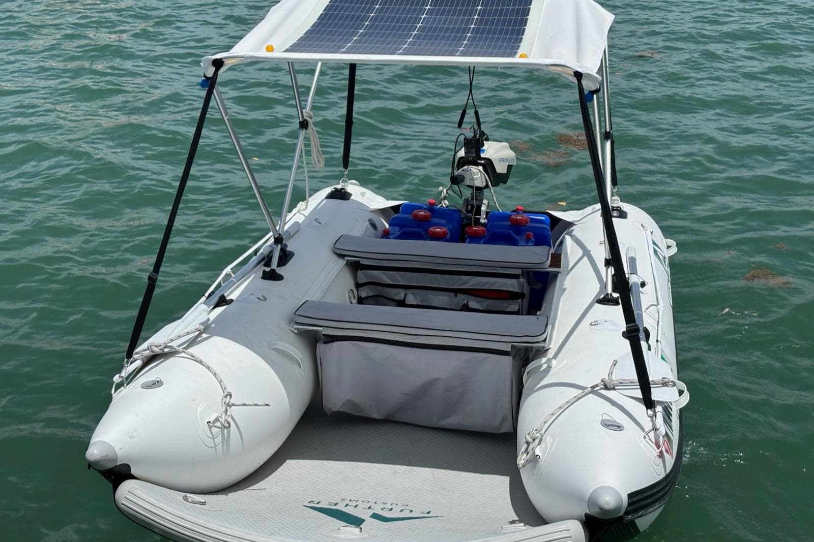 Inflatable boat with solar panel canopy on water, Caliber 38, 1989 model.