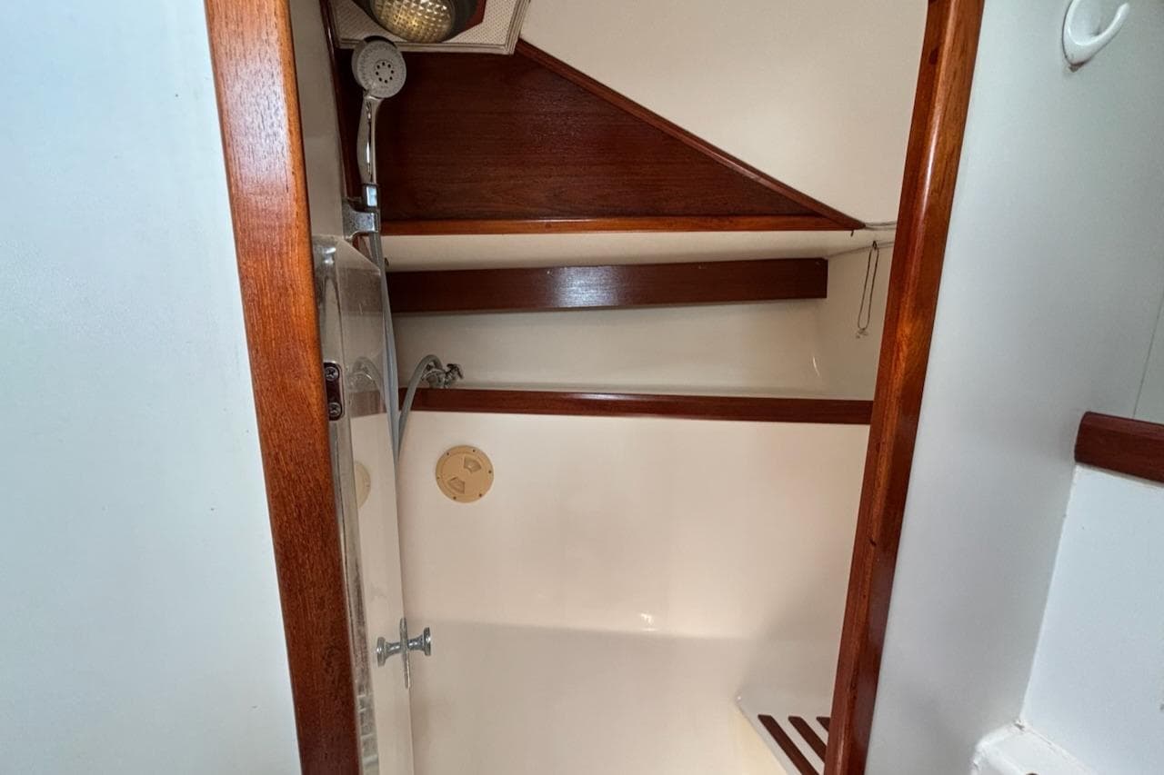 1989 Caliber 38 yacht shower with wooden accents and white interior.