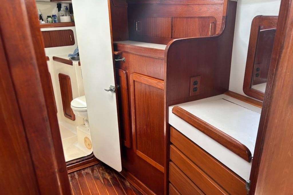 Wooden interior of 1989 Caliber 38 sailboat with bathroom and storage cabinets.