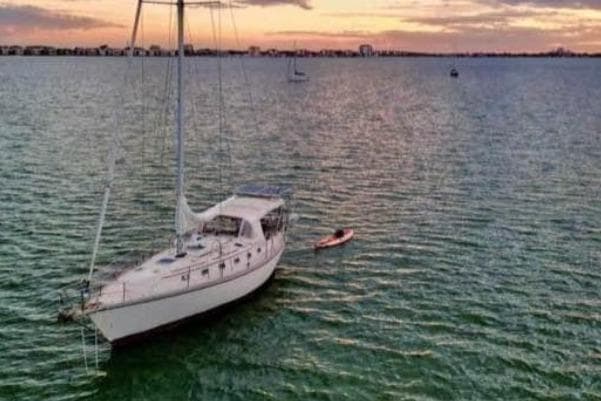 Sailboat on calm water at sunset, Caliber 38, 1989 model.