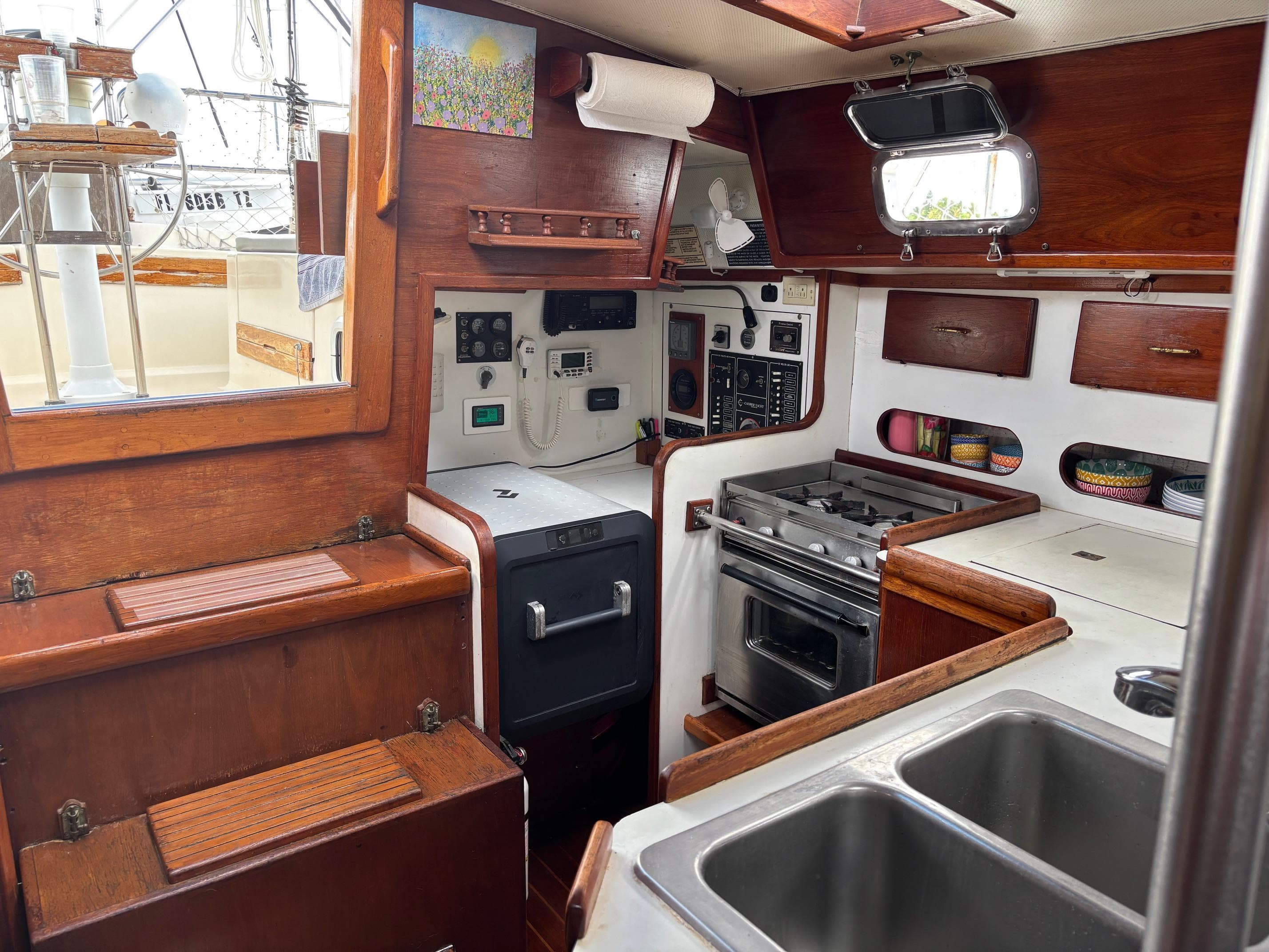 Interior of a 1989 Caliber 38 sailboat kitchen with wood cabinetry and appliances.