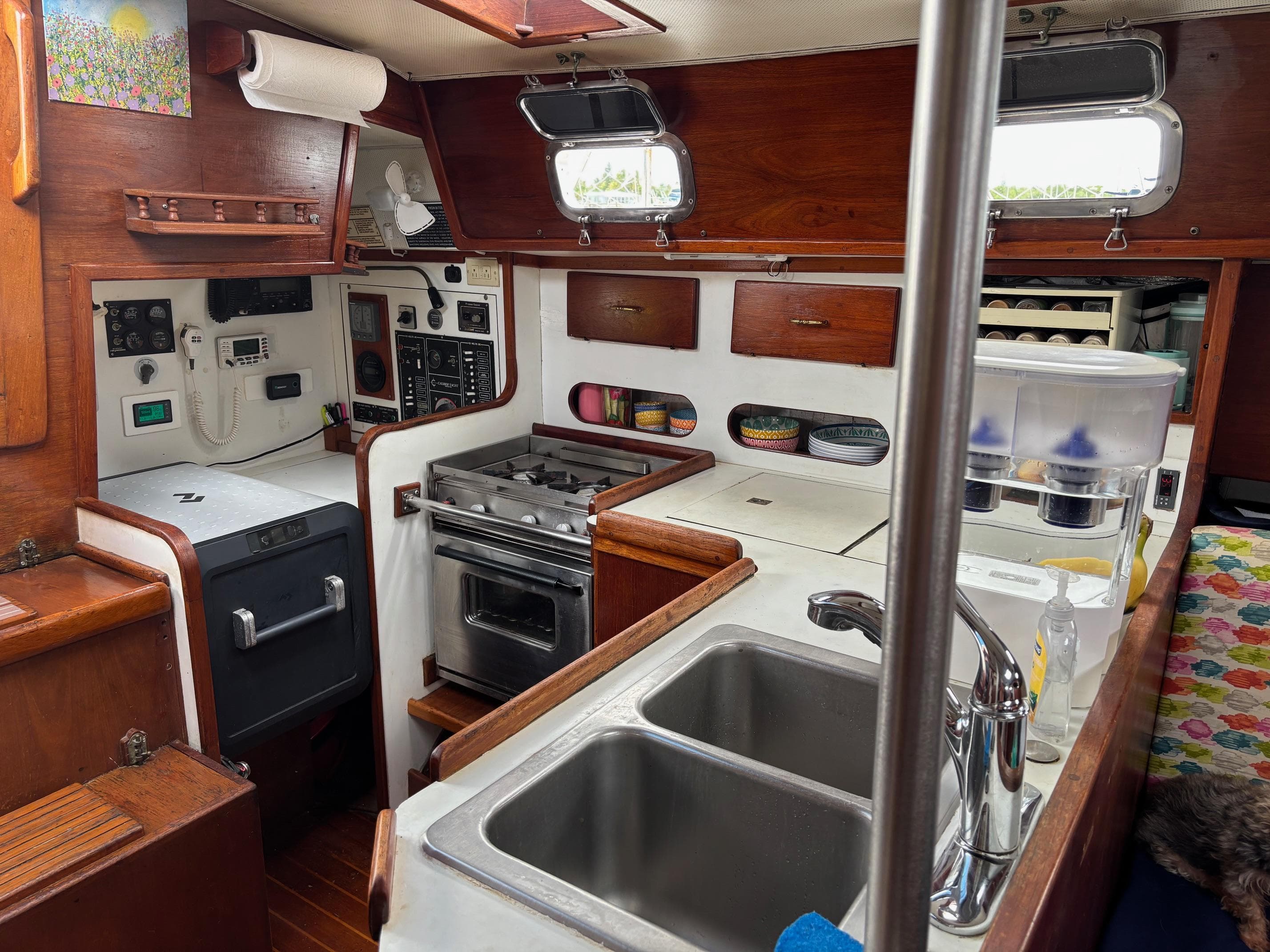 1989 Caliber 38 sailboat galley with stove, sink, and wooden cabinetry.