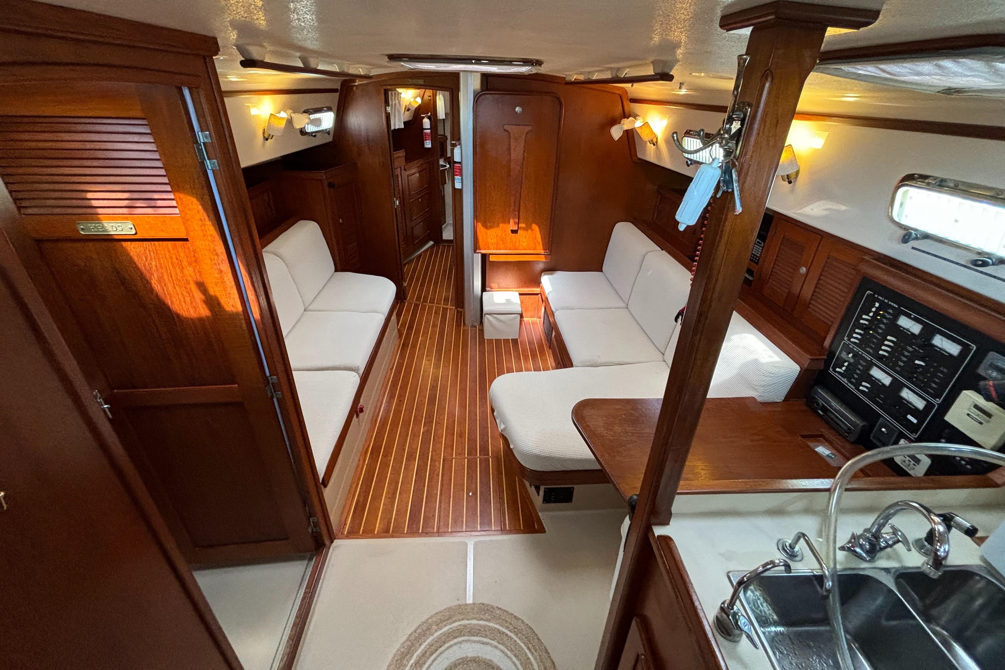 Interior of 1995 Island Packet 40 sailboat with wood finish and cozy seating area.