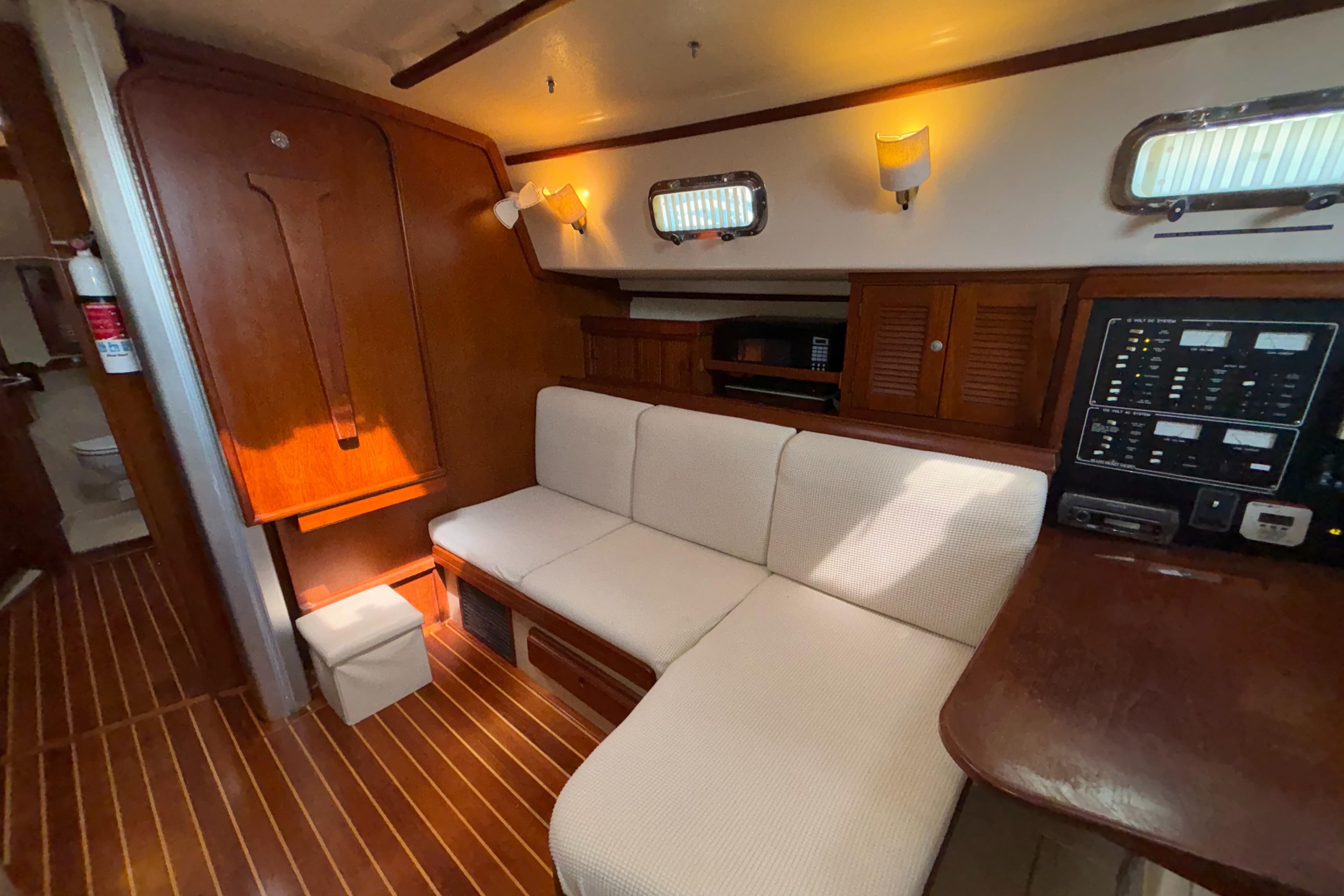 Interior of a 1995 Island Packet 40 sailboat with cozy seating and wooden accents.