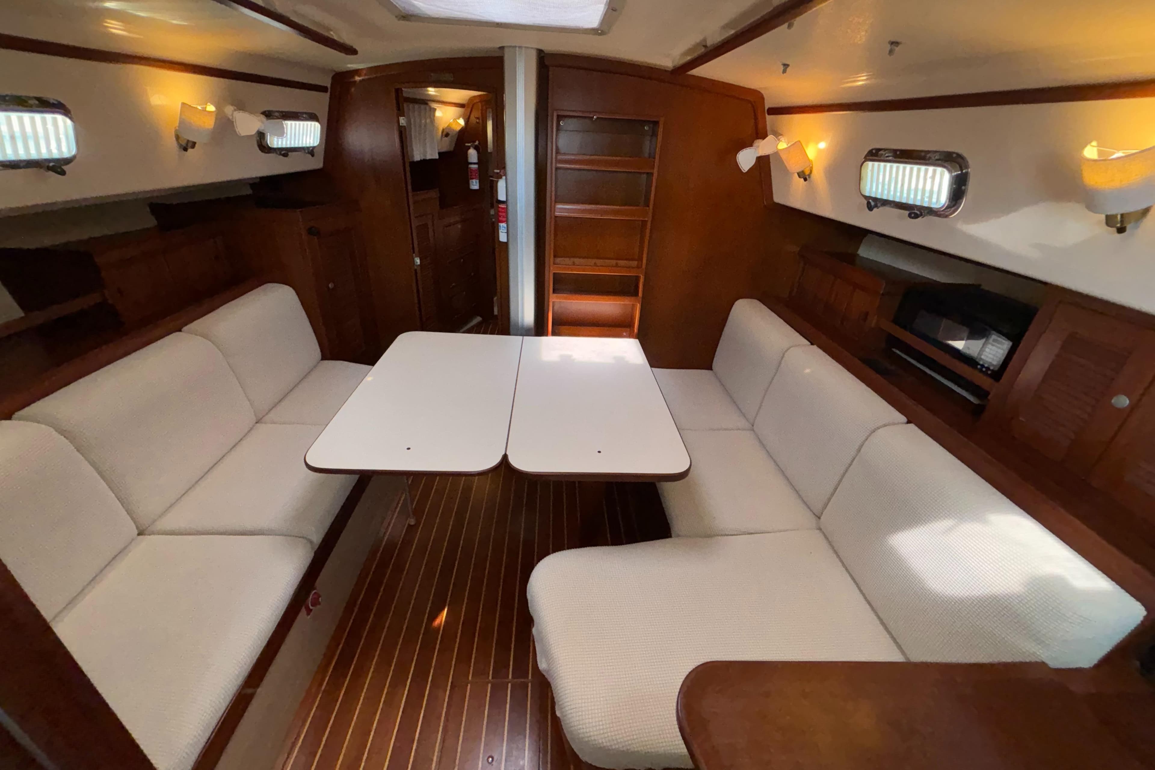 Interior of 1995 Island Packet 40 sailboat with cozy seating and wooden finishes.