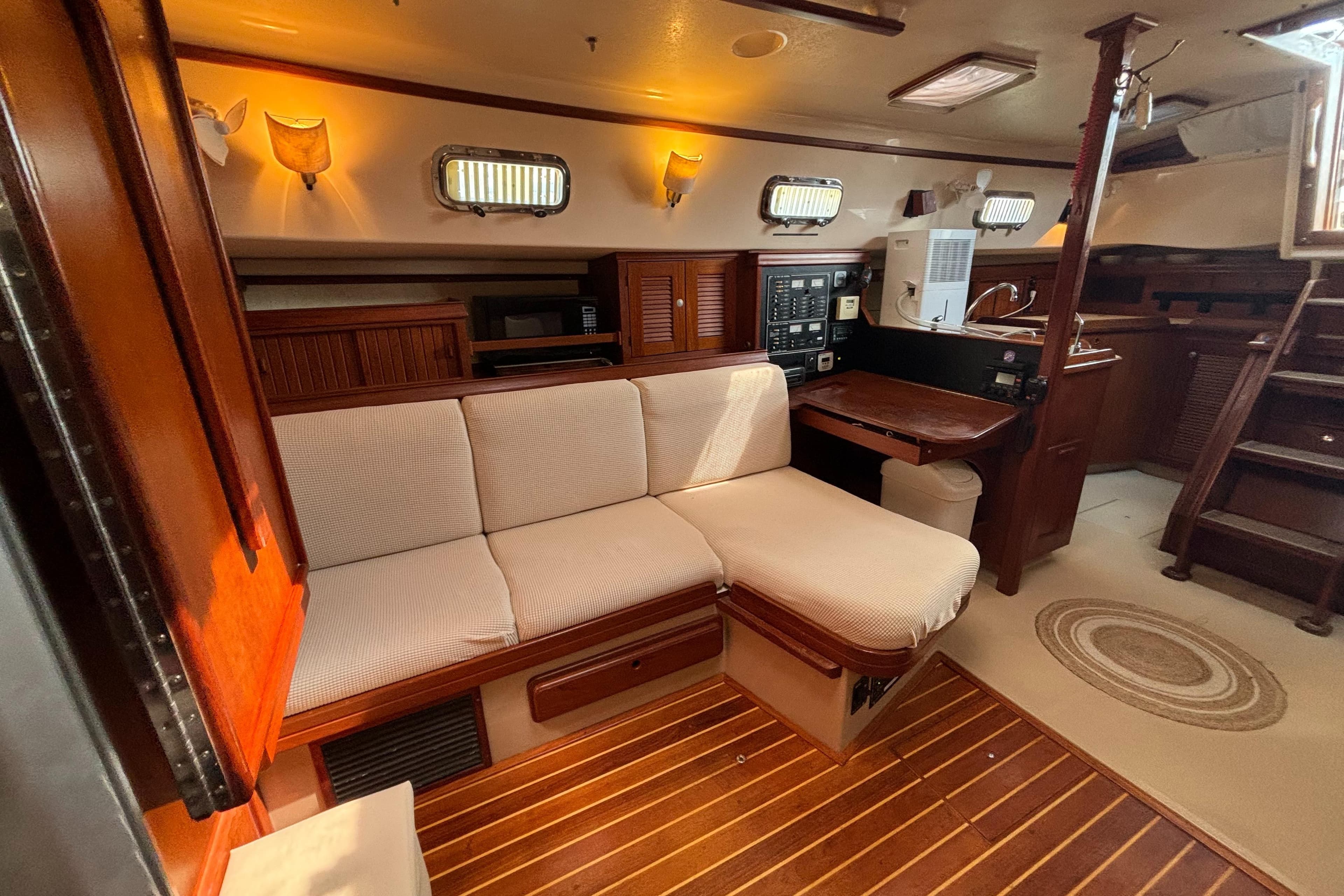 Interior of 1995 Island Packet 40 sailboat with cozy seating and wooden accents.