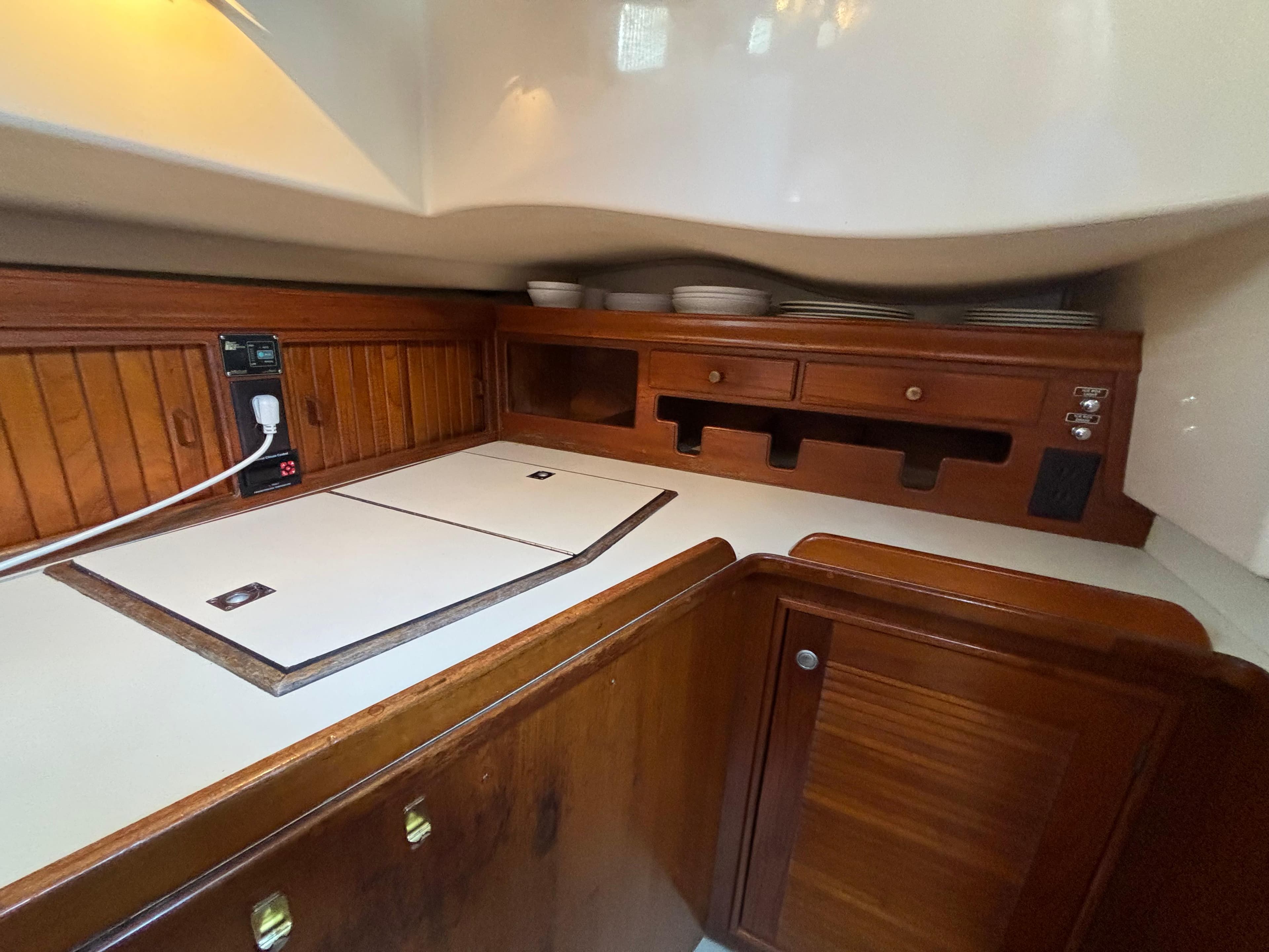 Interior of 1995 Island Packet 40 sailboat galley with wooden cabinetry and countertop.