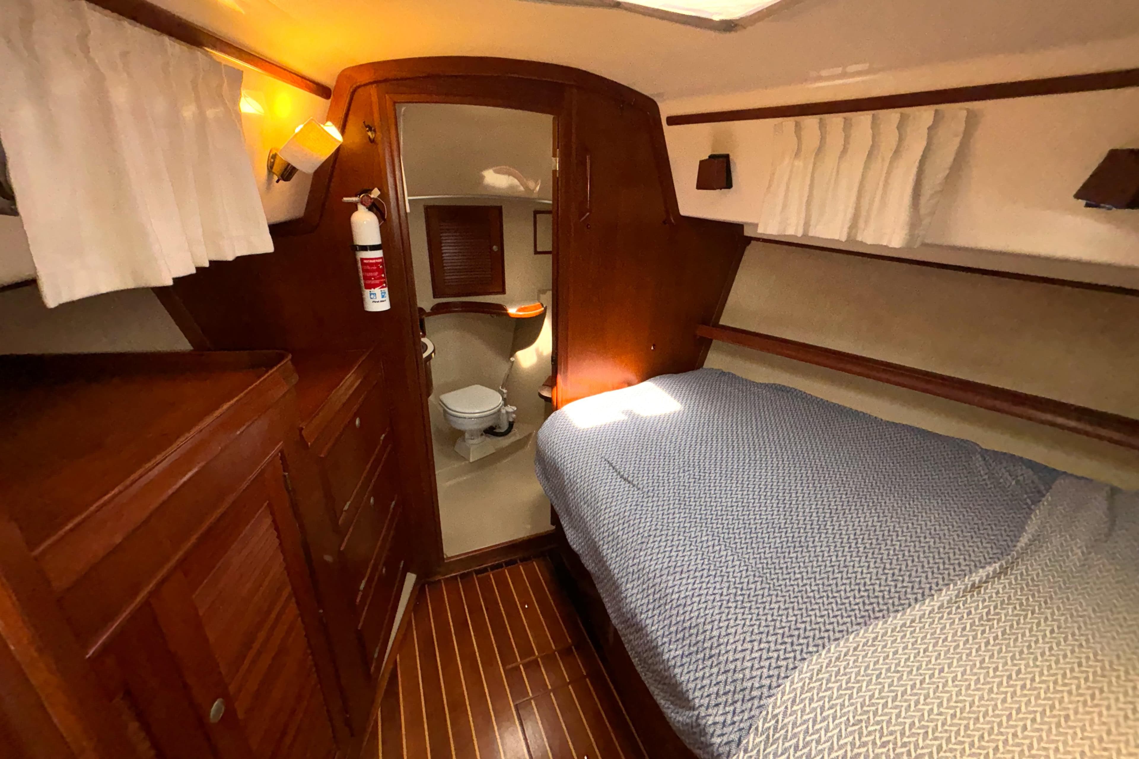 Cozy cabin interior of 1995 Island Packet 40 sailboat with bed and bathroom.