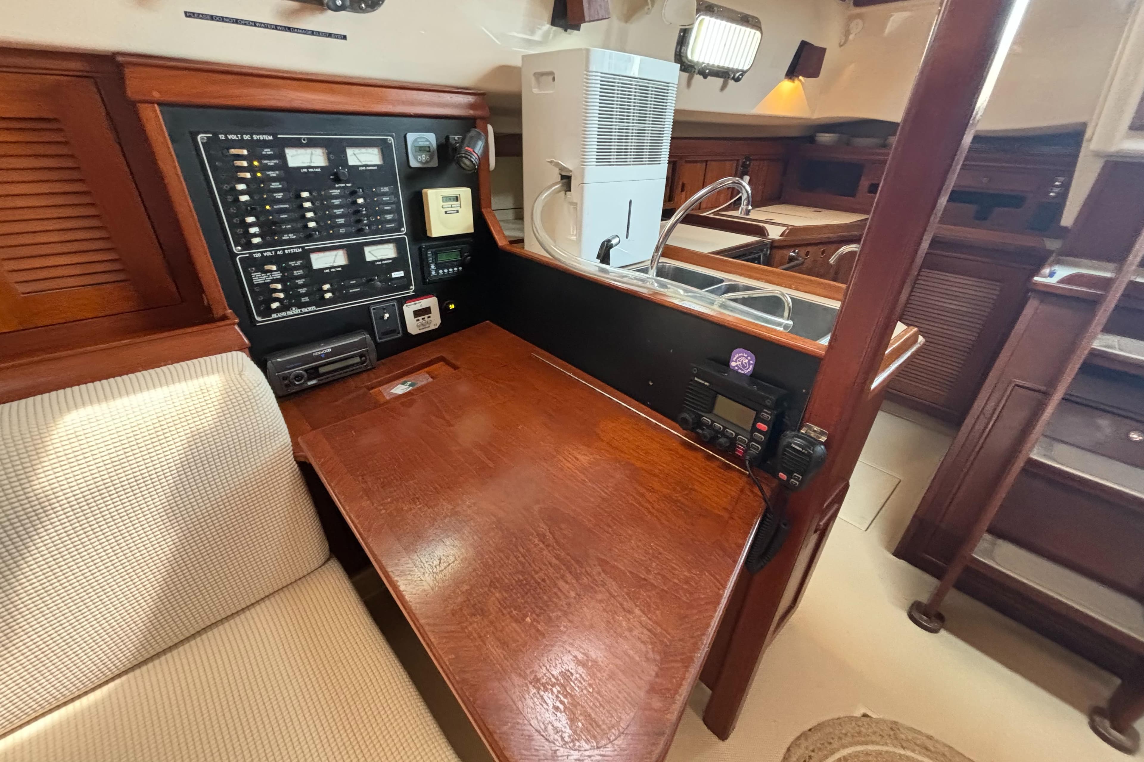 Navigation station in 1995 Island Packet 40 sailboat with control panel and seating.