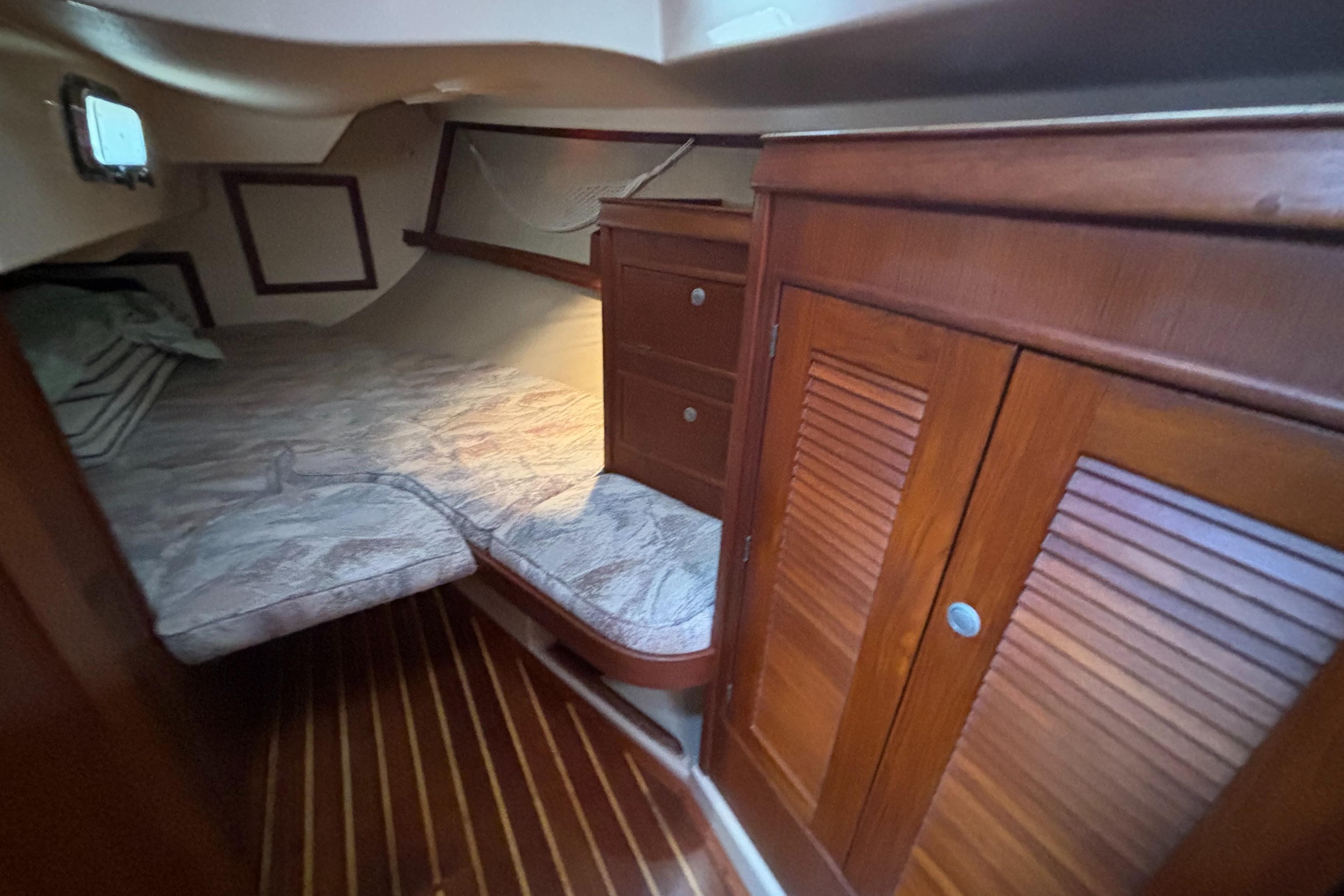 1995 Island Packet 40 sailboat cabin with wooden interior and cozy sleeping area.