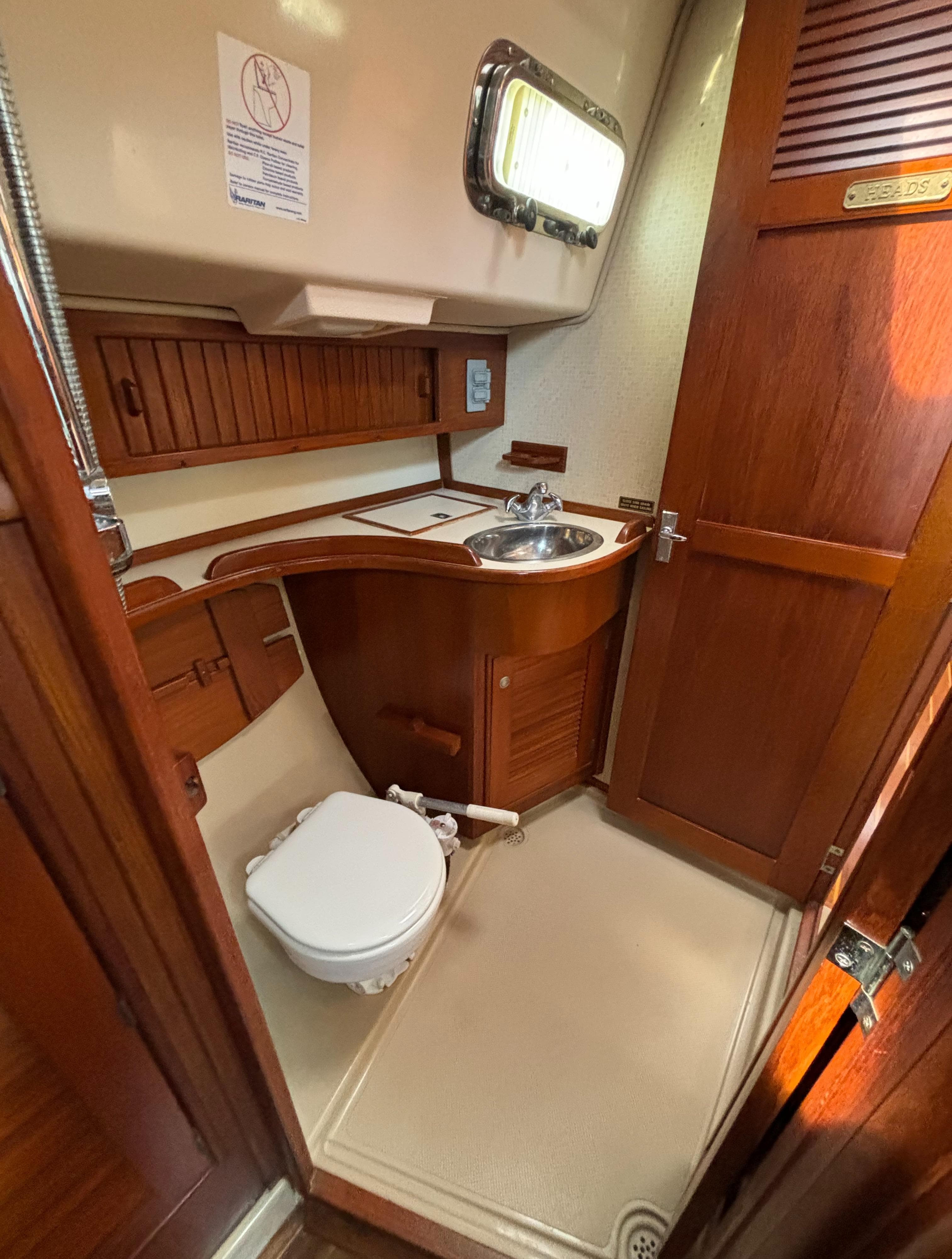 1995 Island Packet 40 yacht bathroom with wooden cabinetry and compact design.