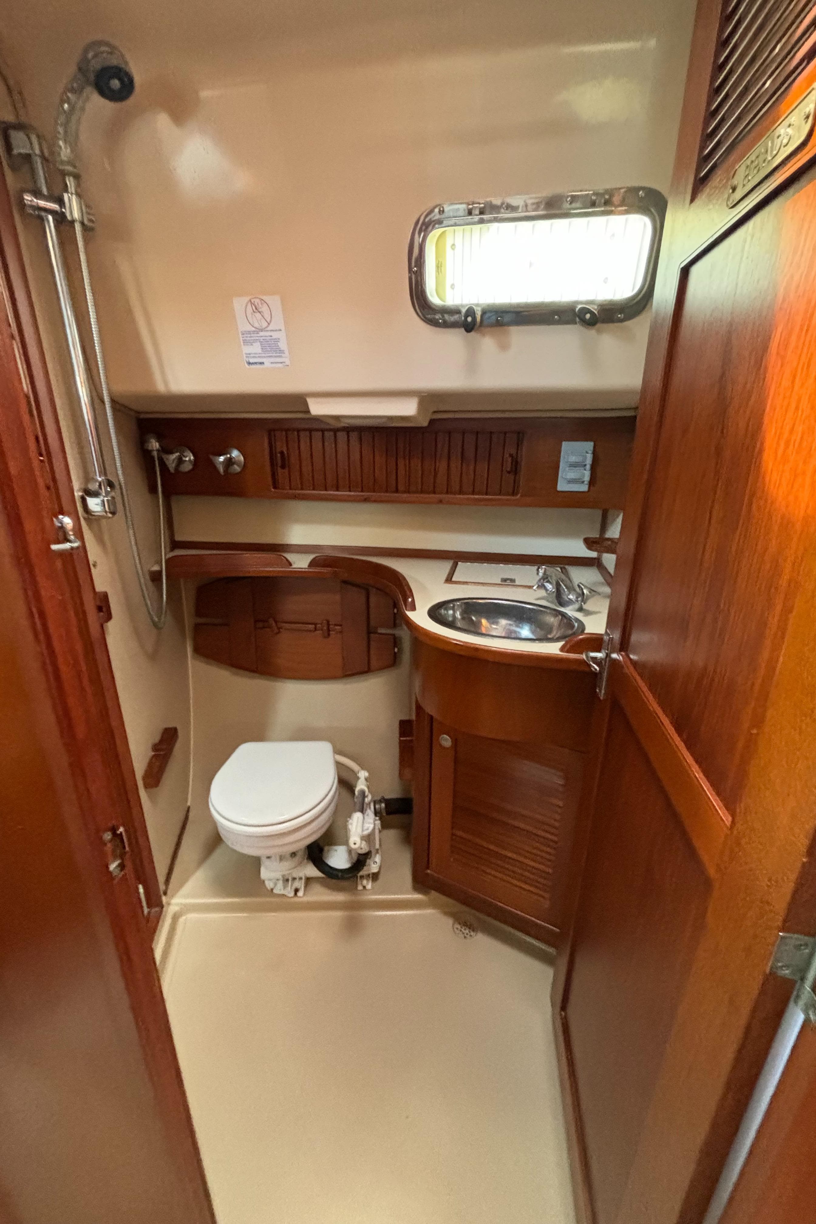 1995 Island Packet 40 yacht bathroom with wooden cabinetry and compact design.