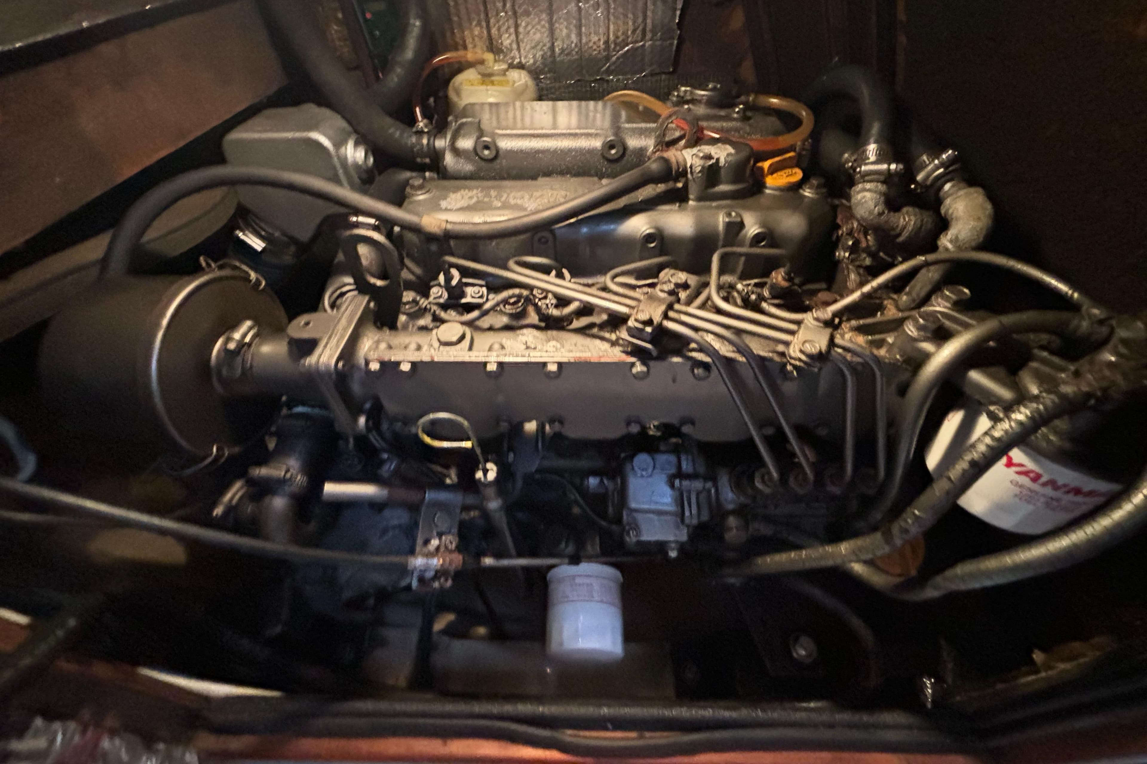 Engine compartment of a 1995 Island Packet 40 sailboat, showcasing detailed mechanical components.