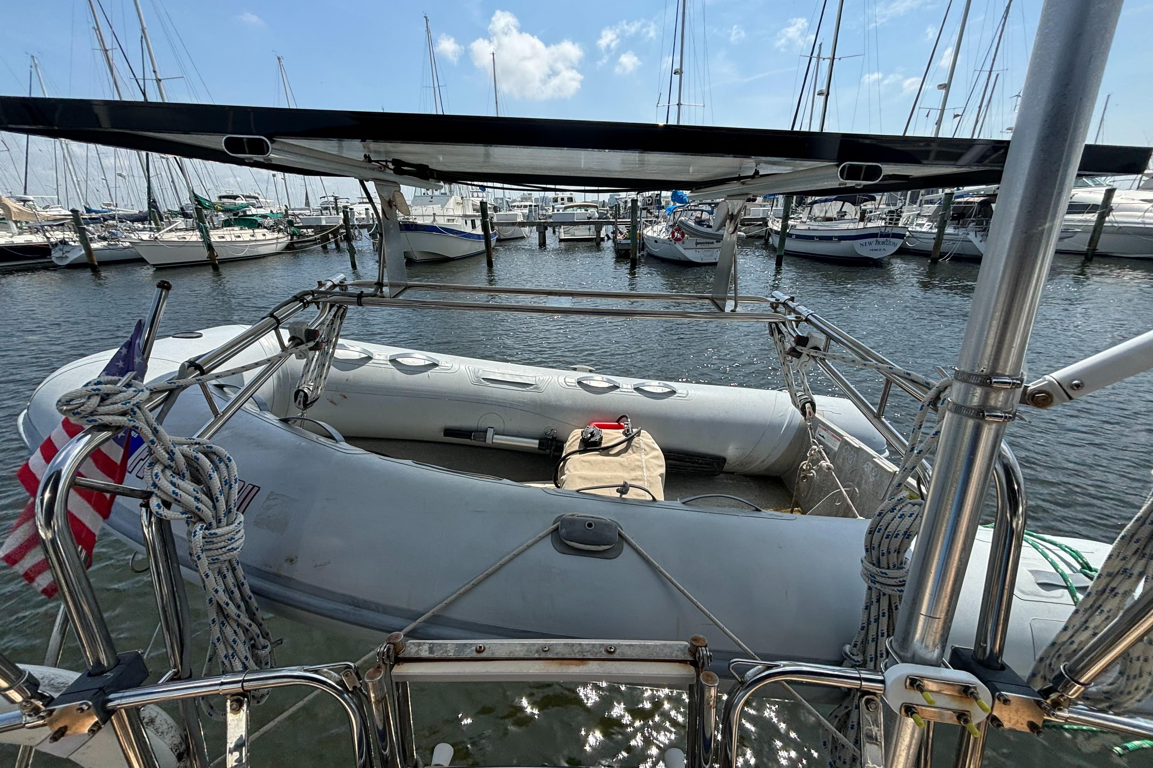 Island Packet 40 sailboat stern view with dinghy, docked in marina, 1995 model.