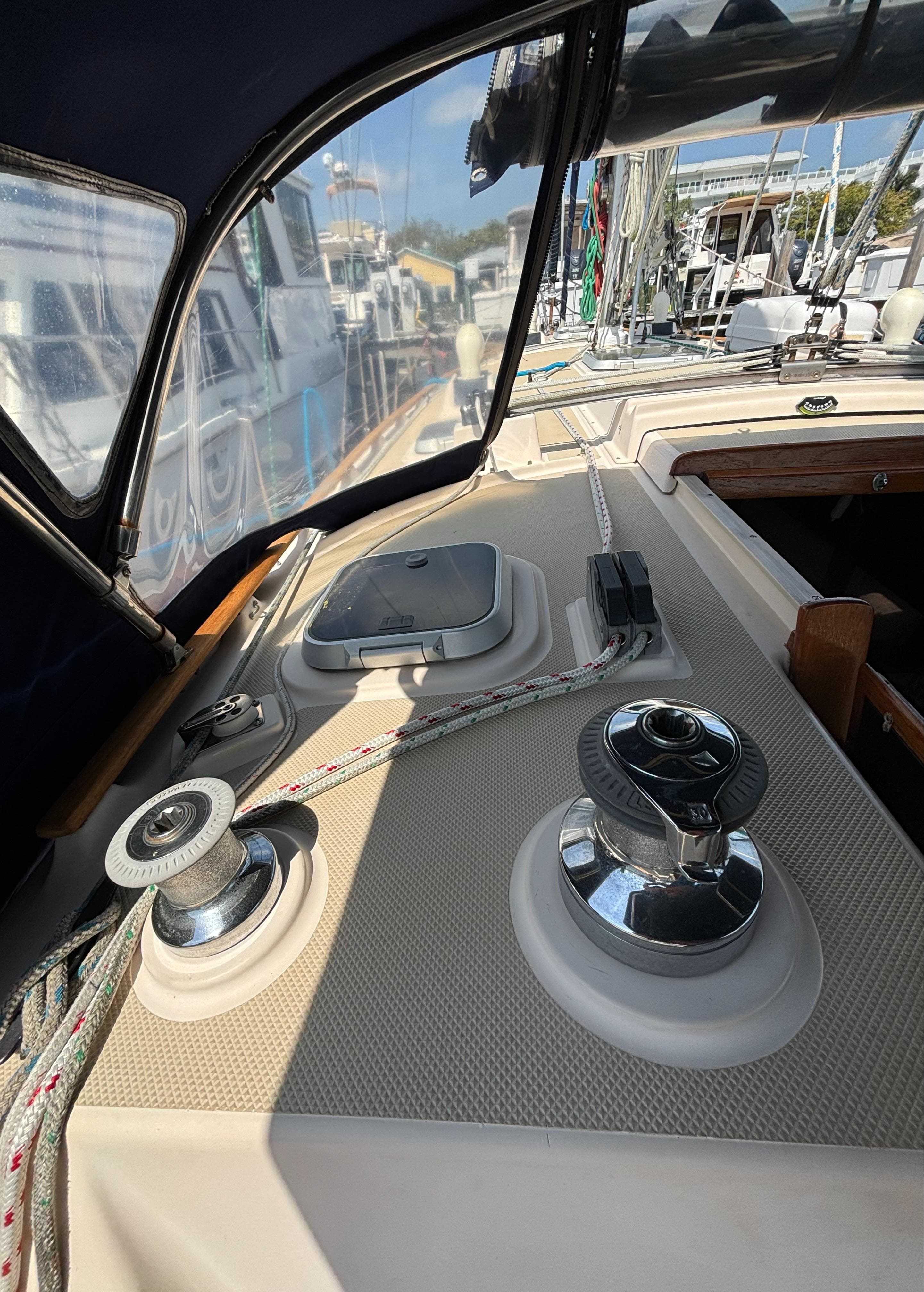1995 Island Packet 40 sailboat deck with winches and ropes in a marina setting.