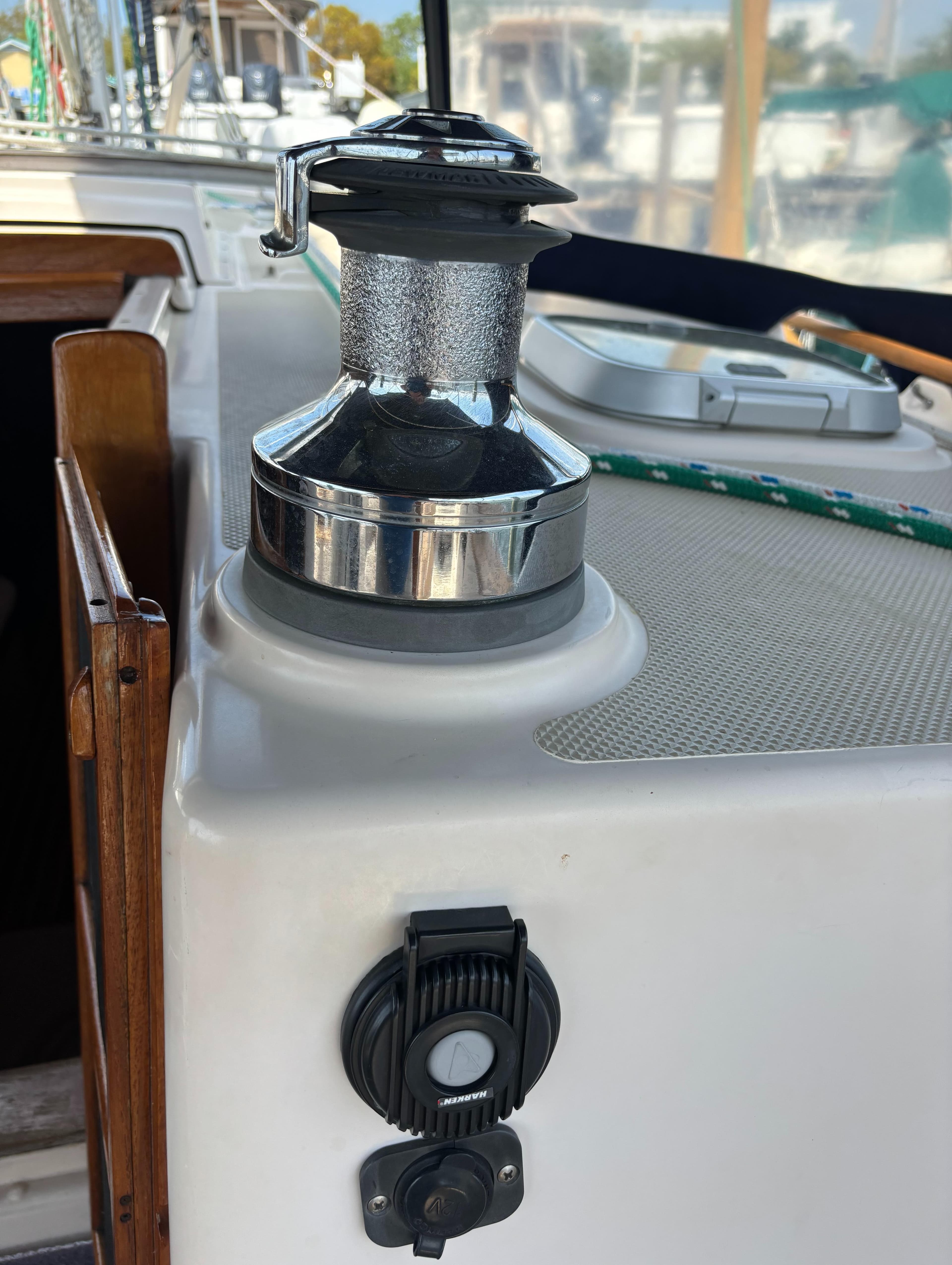 Winch on 1995 Island Packet 40 sailboat deck, with rope and control panel.