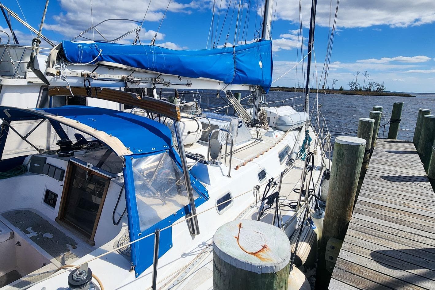 1980 Nordic 44 sailboat docked, featuring blue covers and clear skies.