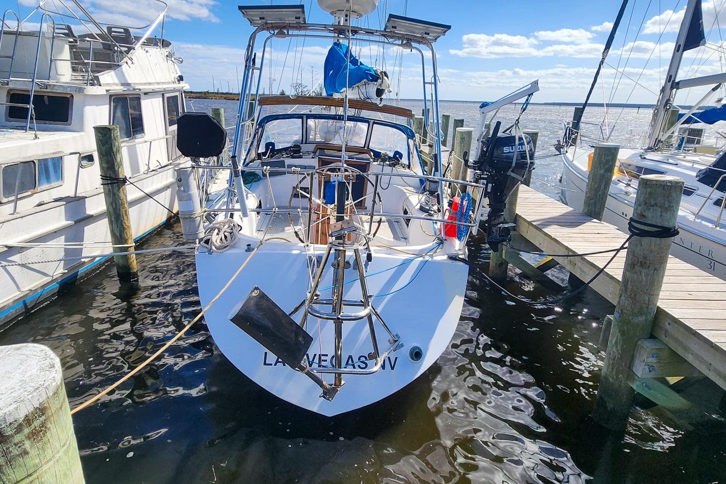 1980 Nordic 44 sailboat docked at marina, clear sky, calm water.