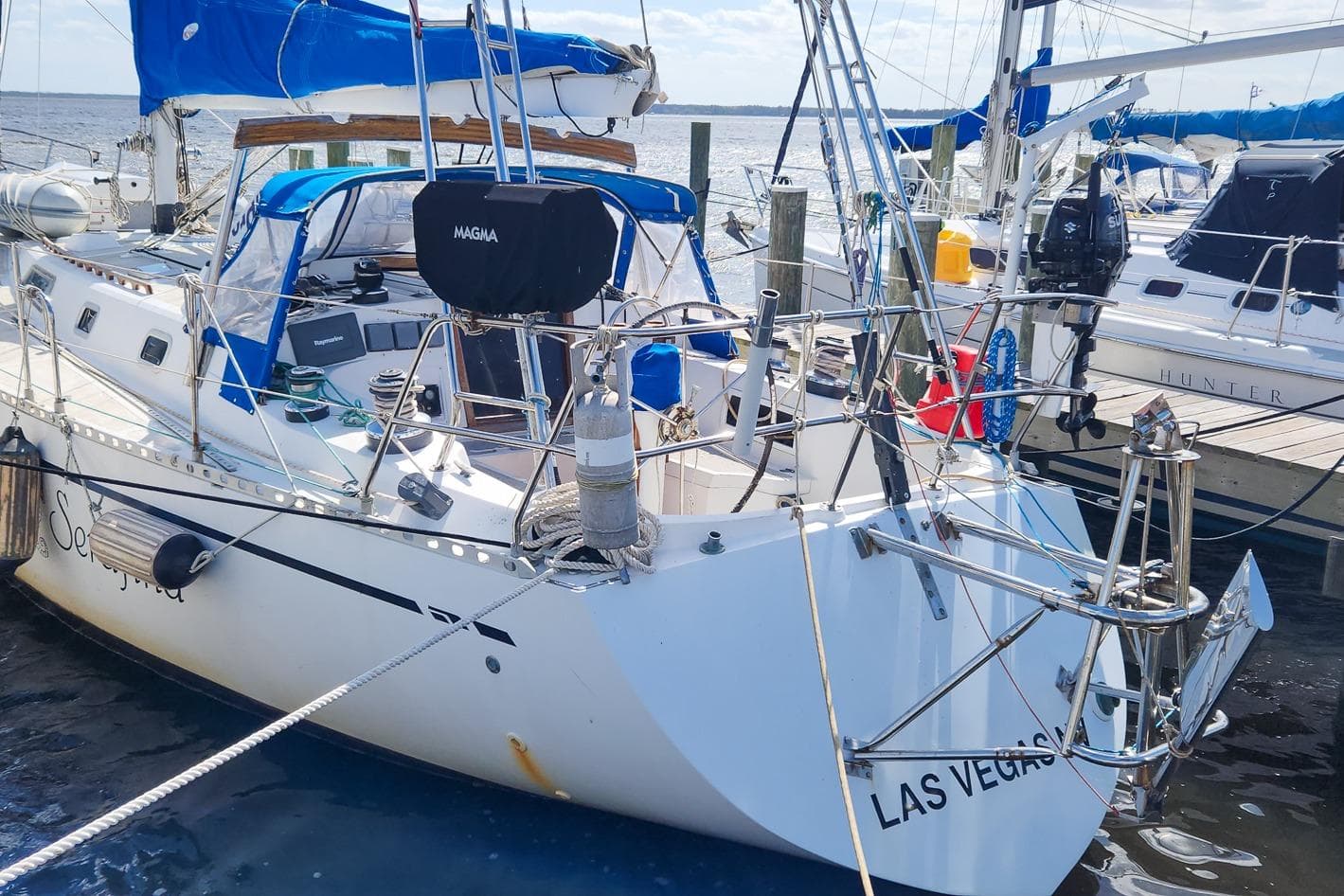 Sailboat Nordic 44 from 1980 docked, featuring blue sails and a Magma grill.