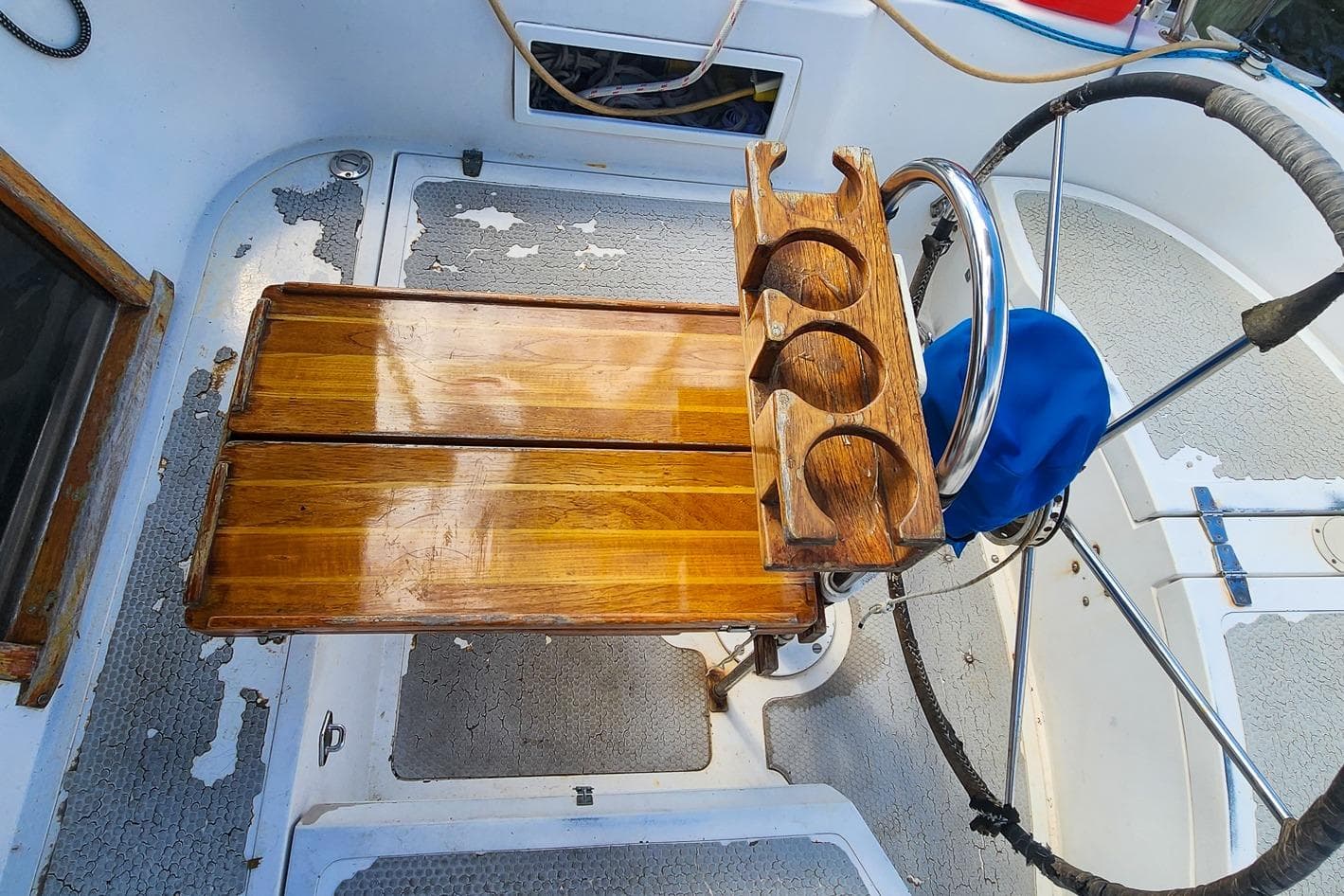 Cockpit of 1980 Nordic 44 sailboat with wooden table and cup holders.