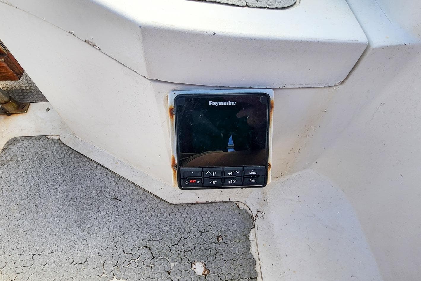 Raymarine navigation device on 1980 Nordic 44 boat with worn flooring.
