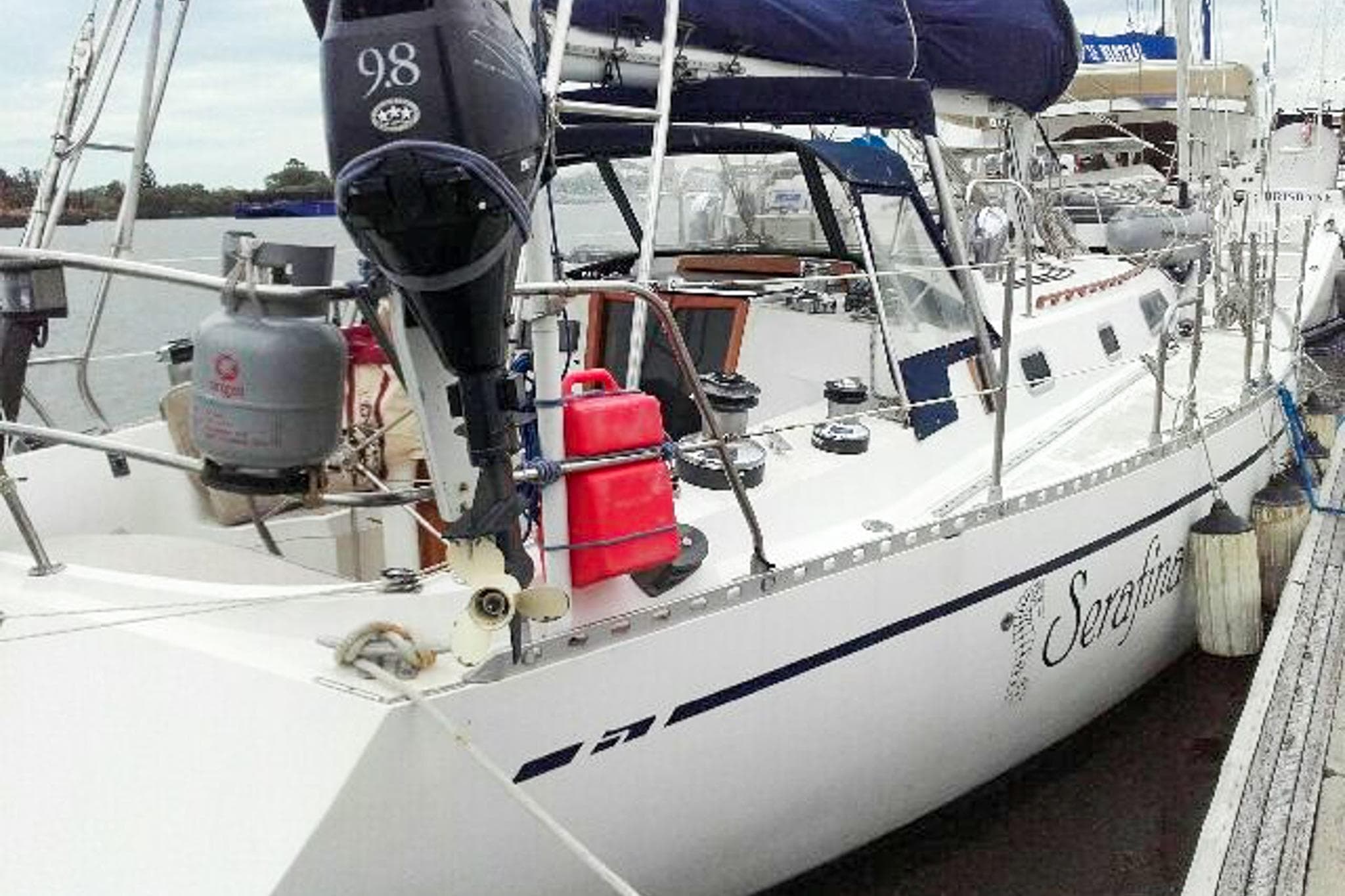 1980 Nordic 44 sailboat docked, featuring outboard motor and propane tank.