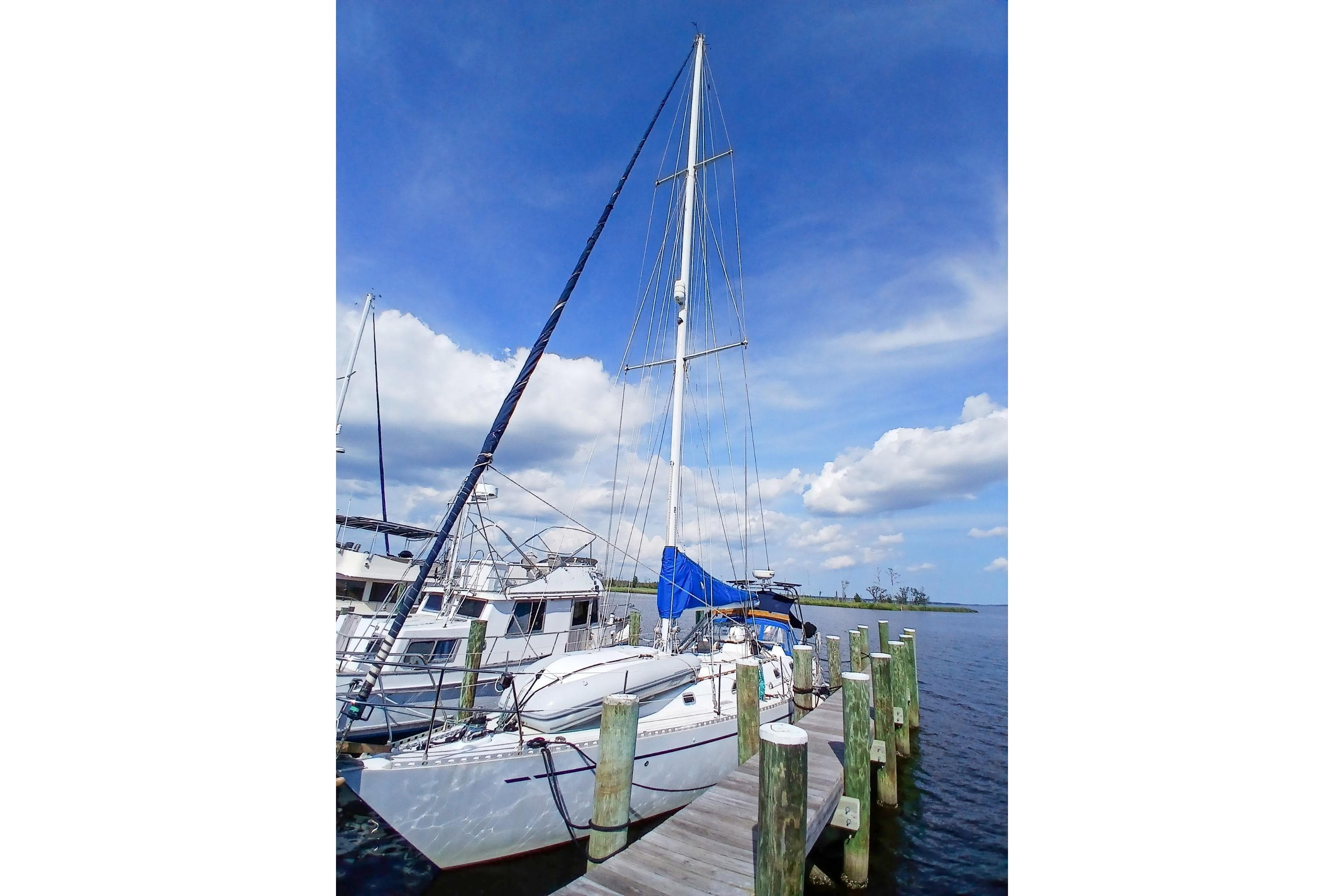 1980 Nordic 44 sailboat docked at marina under clear blue sky.