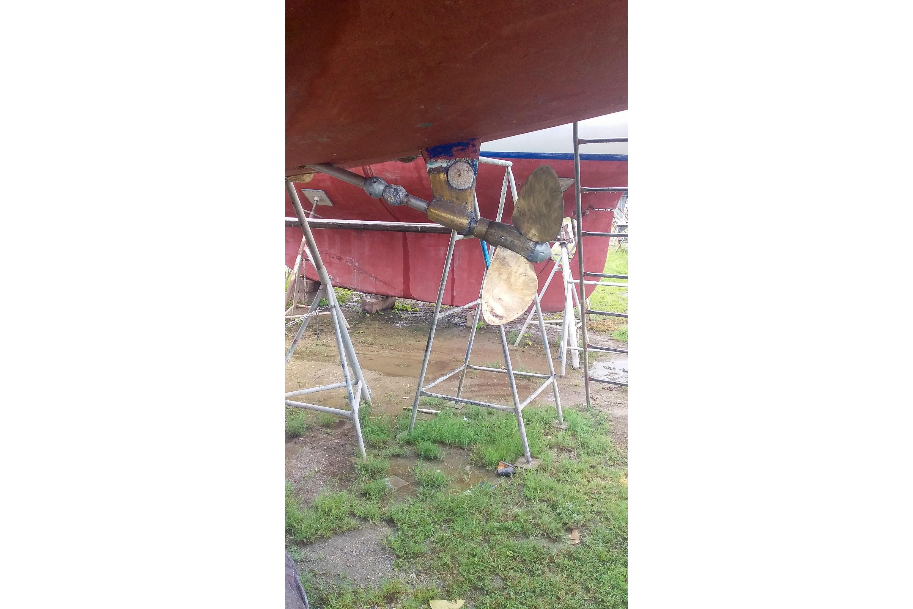 1980 Nordic 44 sailboat propeller and rudder on stands, outdoor setting.