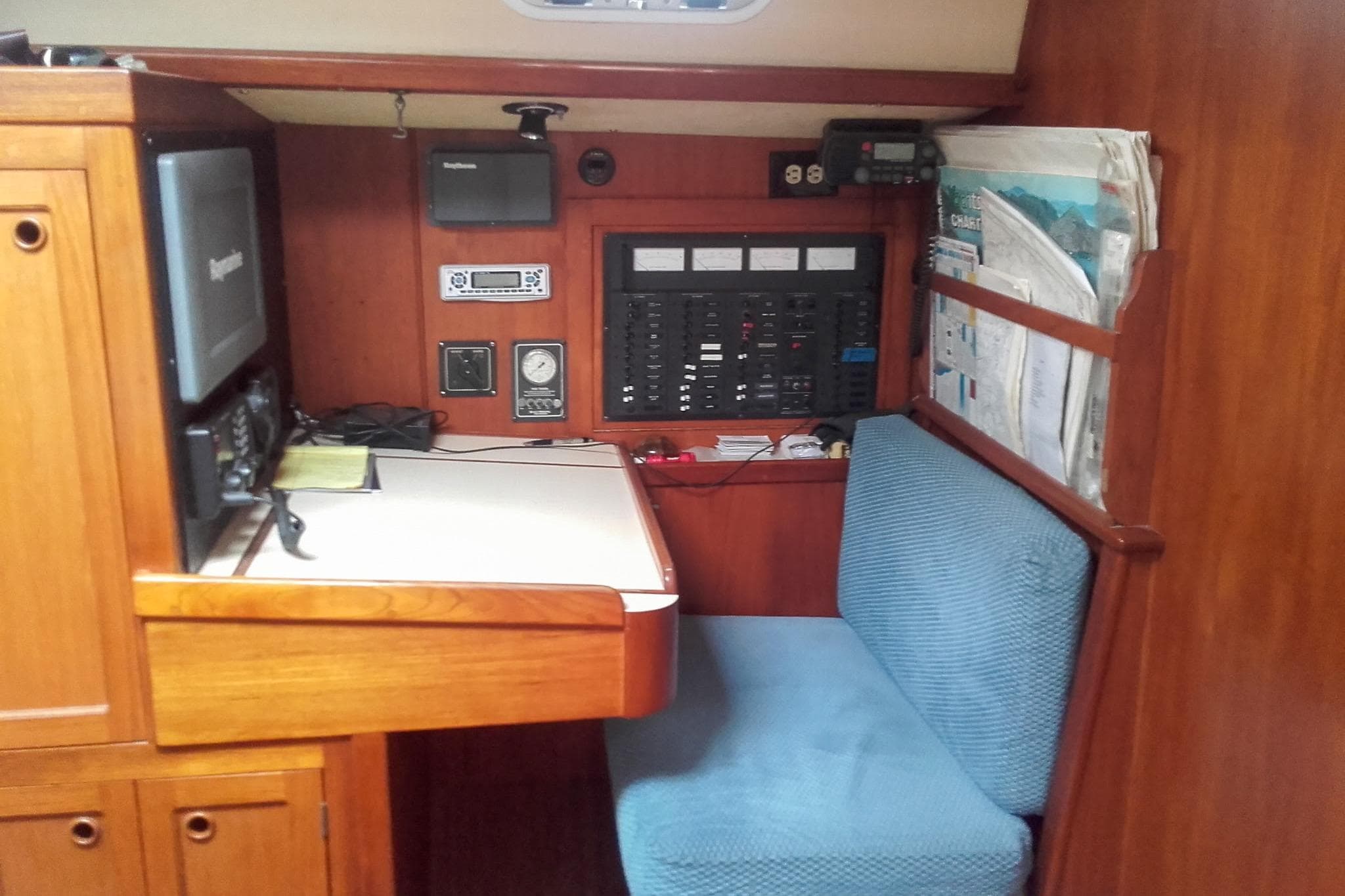 Navigation station in a 1980 Nordic 44 sailboat with control panels and seating.