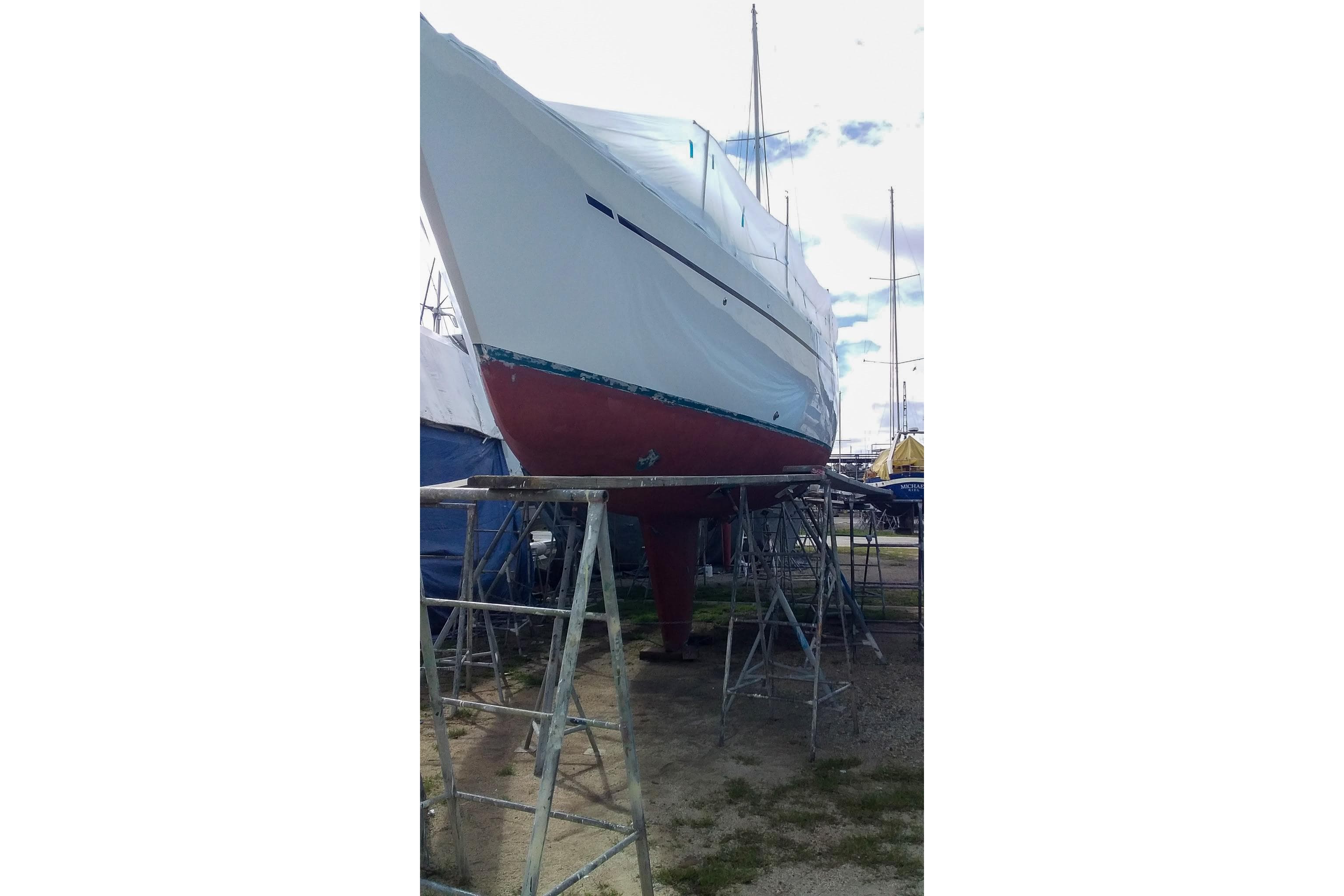1980 Nordic 44 sailboat on stands, undergoing maintenance in a boatyard.