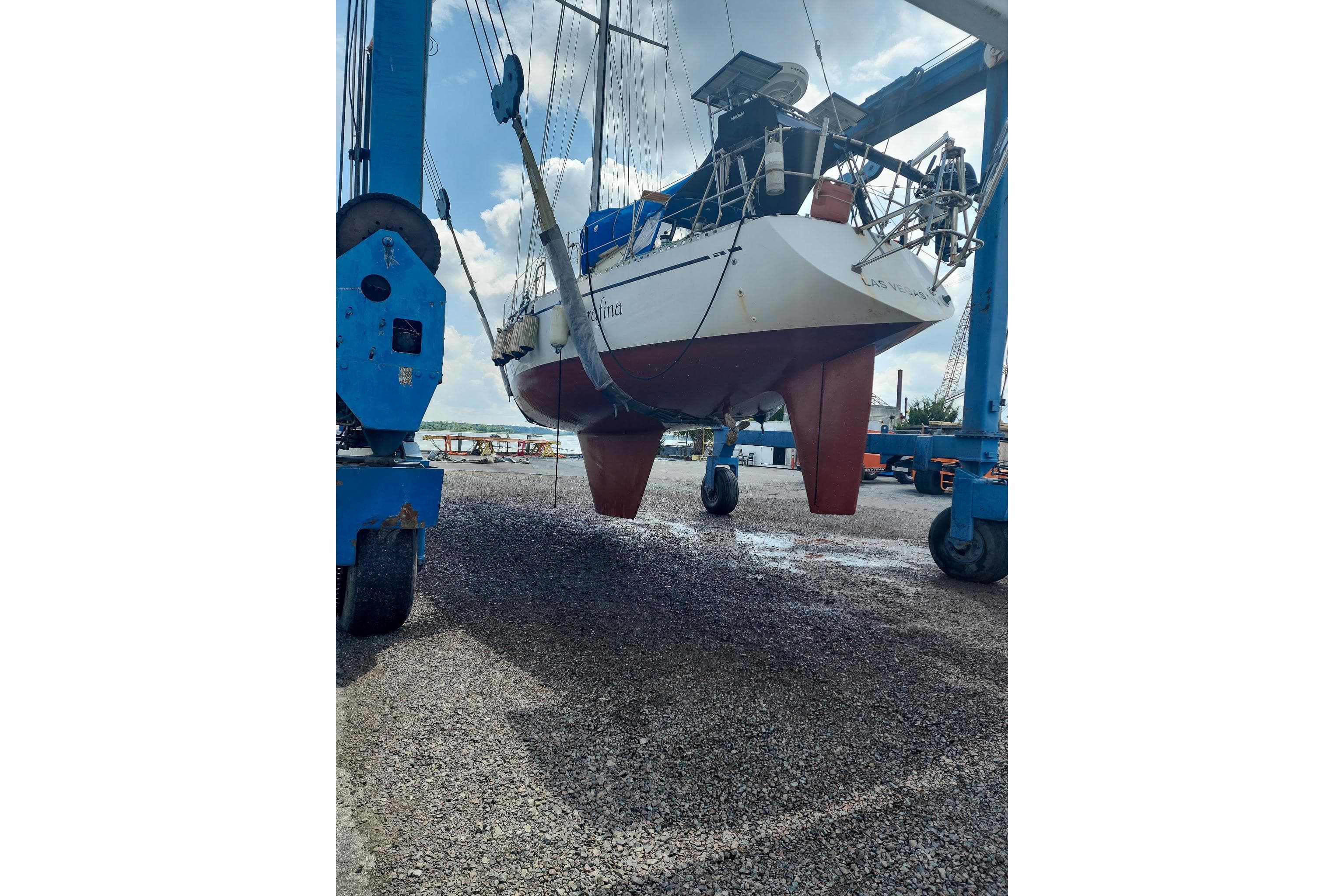 Nordic 44 sailboat from 1980 being lifted in a boatyard.