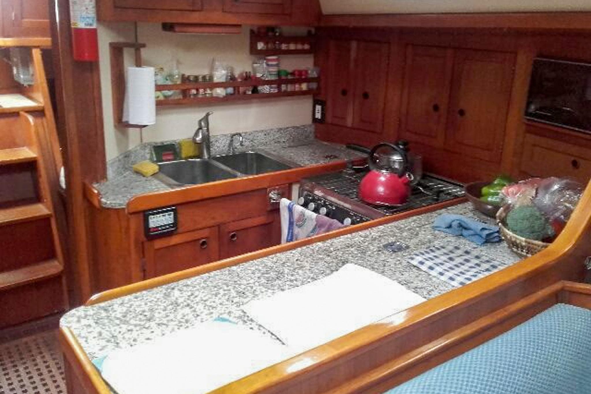 Cozy kitchen in 1980 Nordic 44 sailboat with wooden cabinets and granite countertops.
