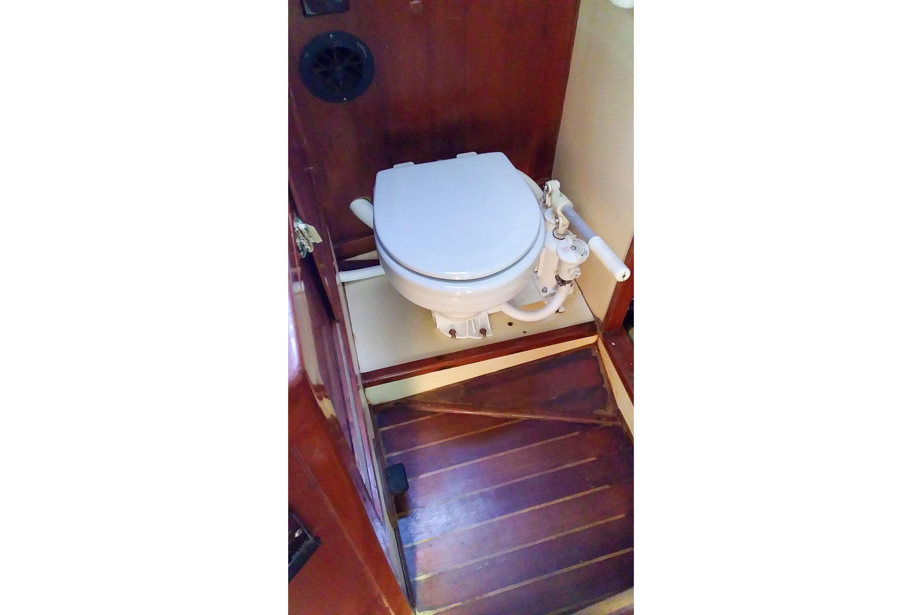 Vintage 1980 Nordic 44 boat toilet with wooden flooring and manual pump.