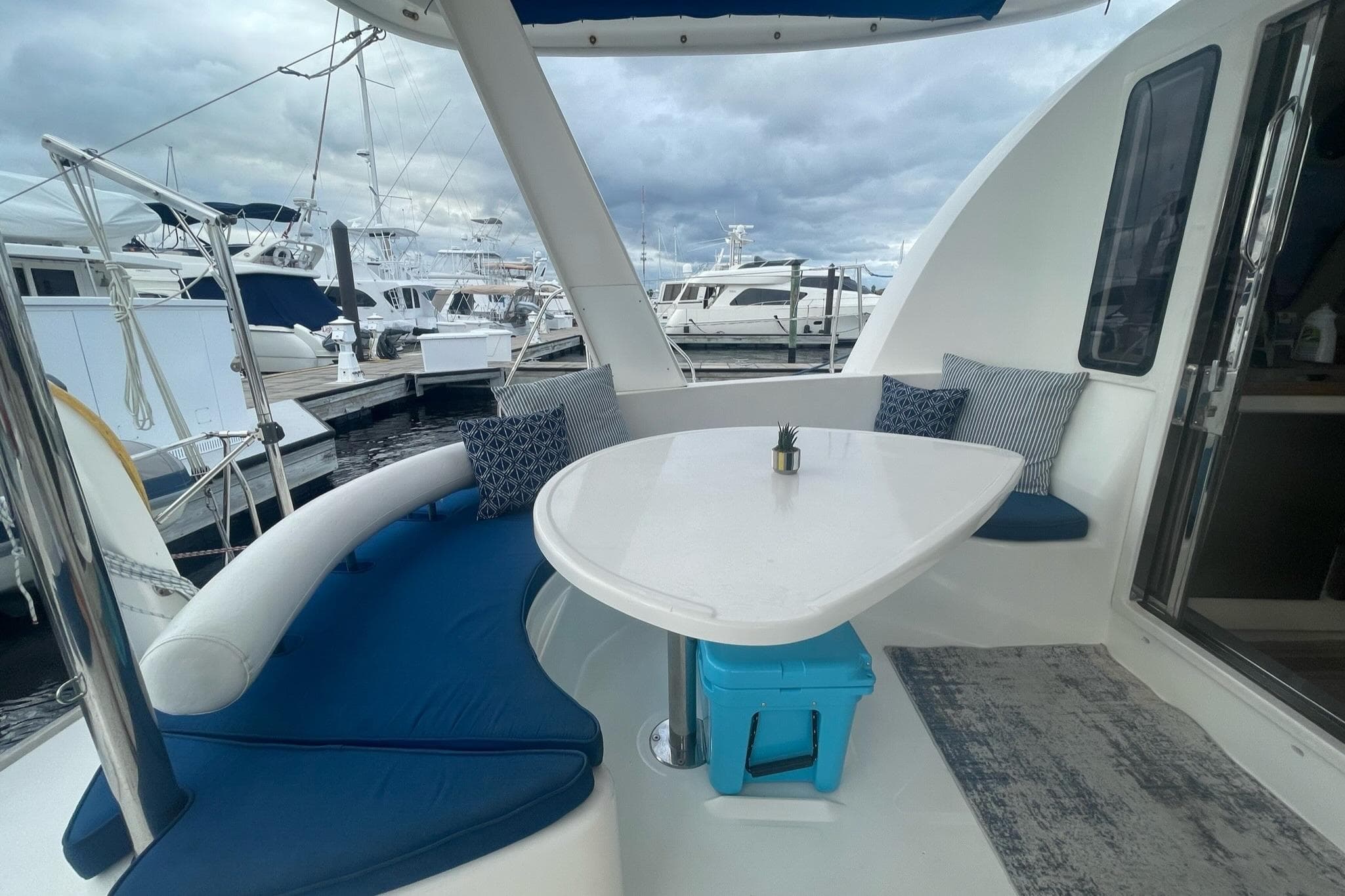 Outdoor seating area on a 2006 Leopard 40 yacht, featuring a white table and blue cushions.