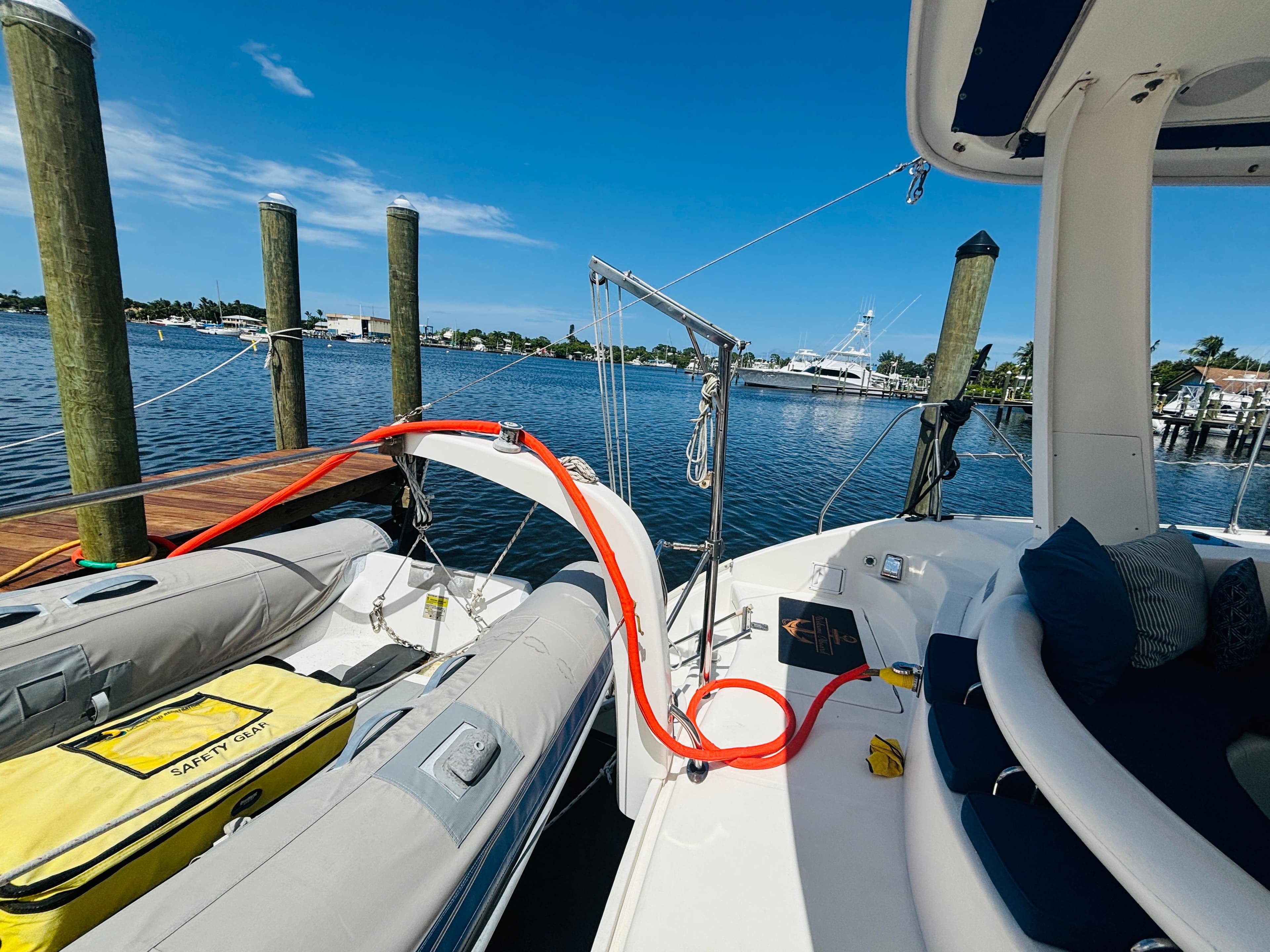 2006 Leopard 40 catamaran docked, featuring inflatable dinghy and safety gear under clear blue sky.