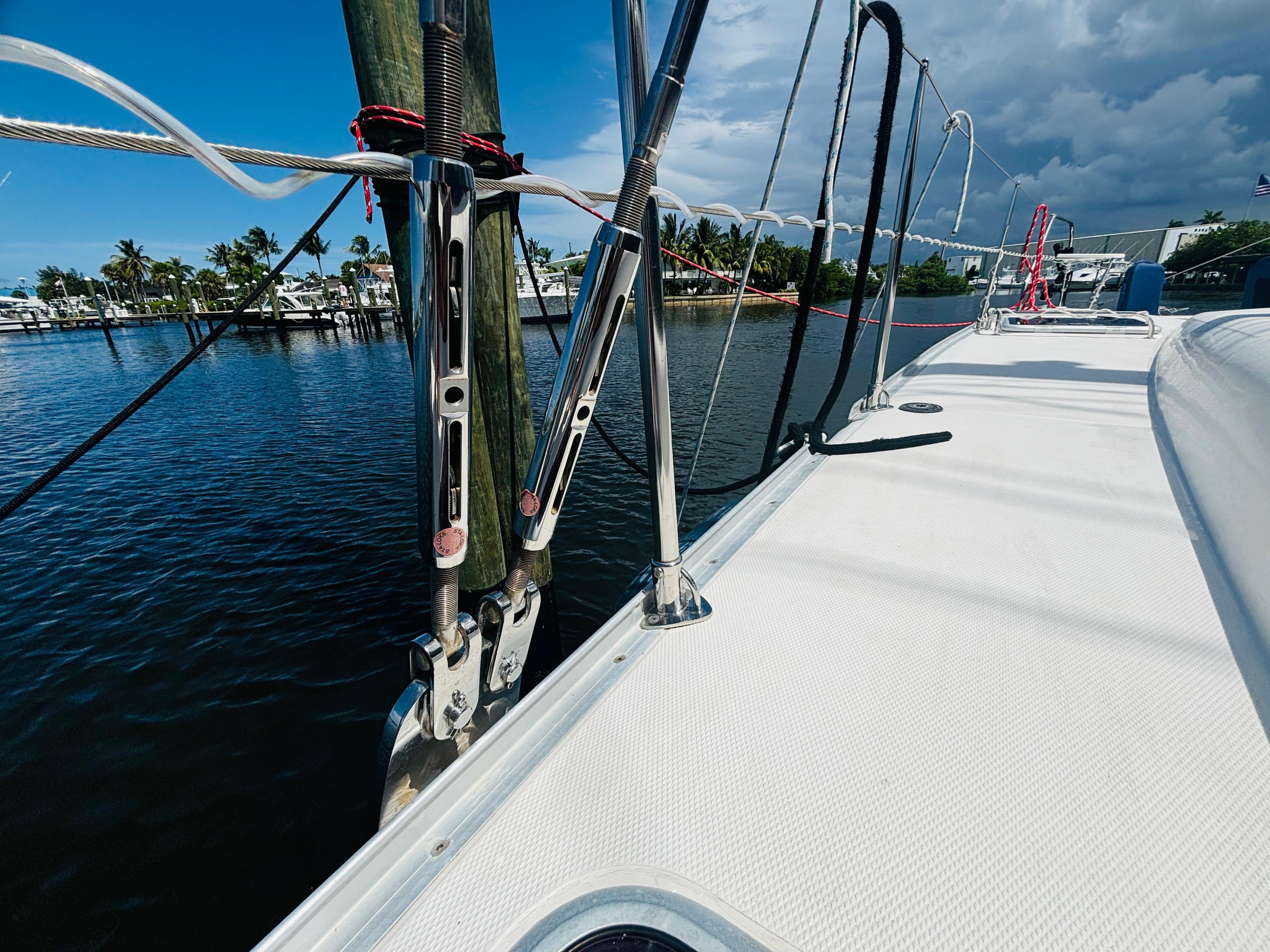 Sailboat deck view, Leopard 40, 2006 model, docked by calm waters under cloudy sky.