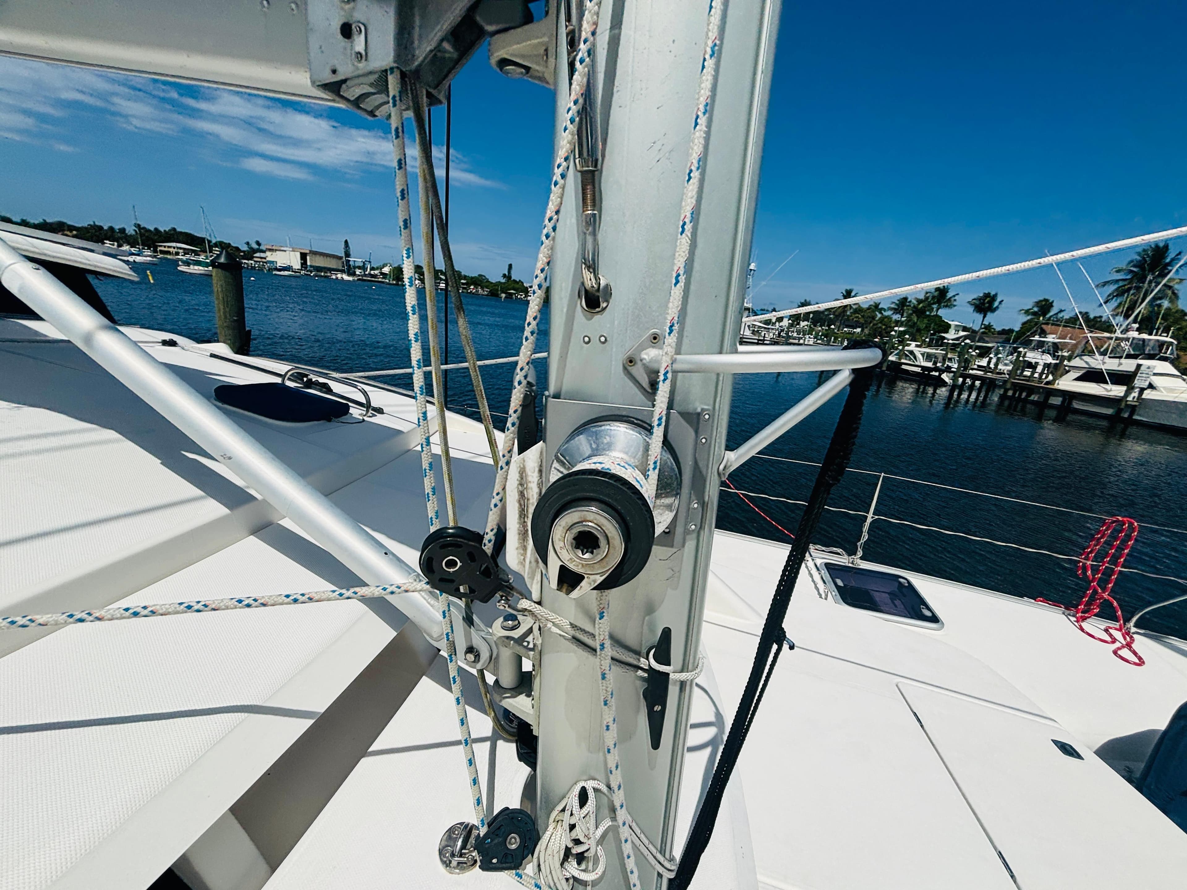 Sailboat rigging on a 2006 Leopard 40 catamaran, docked by a scenic waterfront.