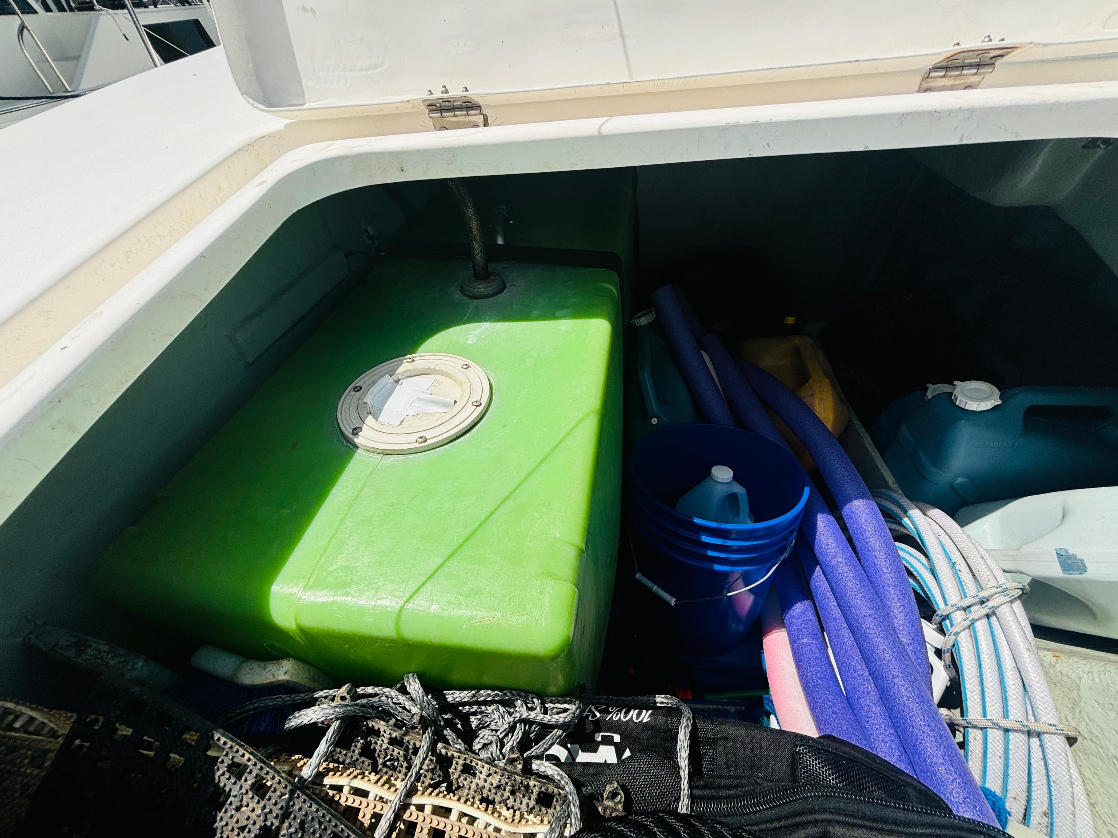 Storage compartment on a 2006 Leopard 40 boat with green tank and various equipment.