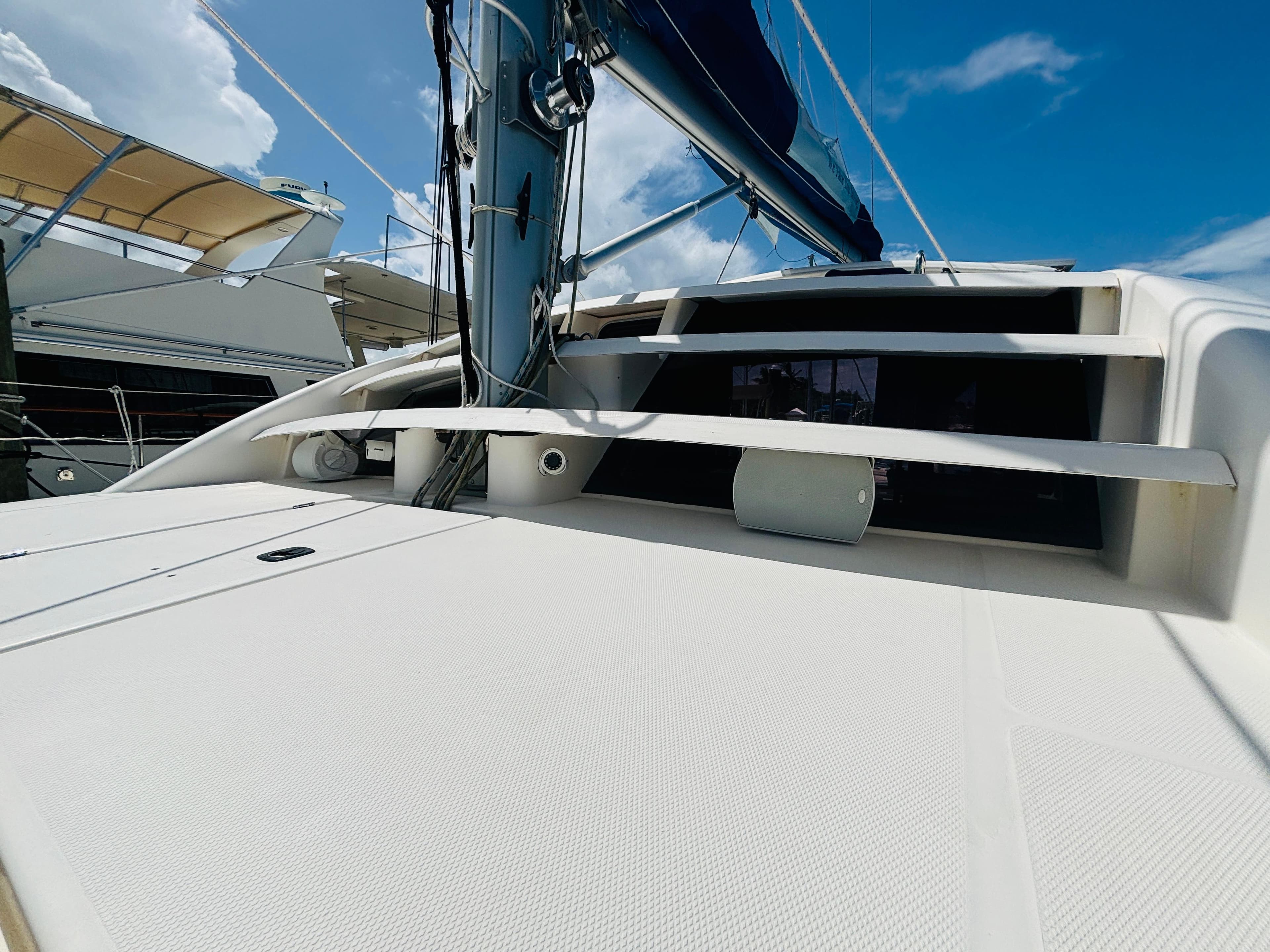 2006 Leopard 40 catamaran deck with mast, under clear blue sky.