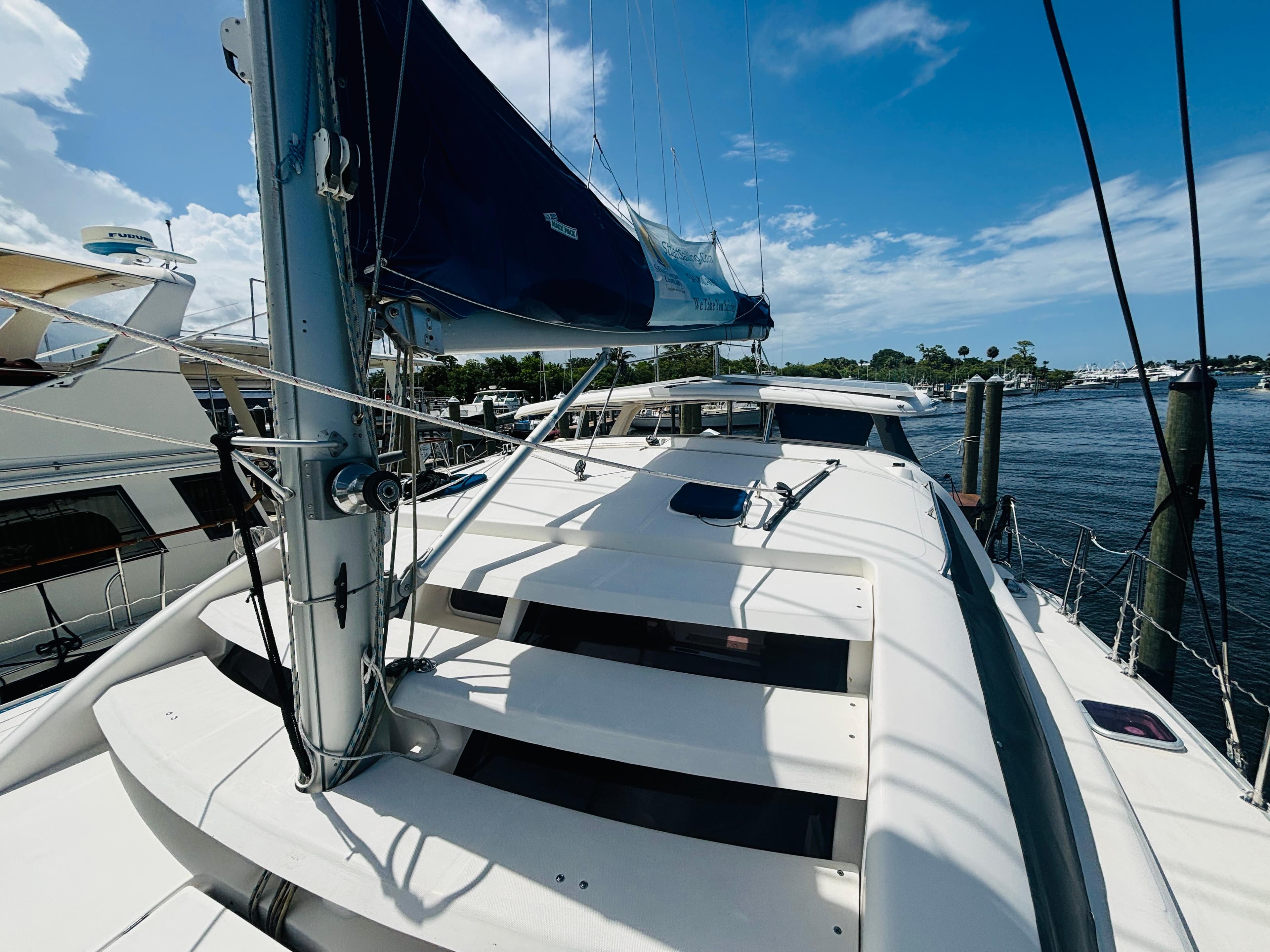 2006 Leopard 40 catamaran docked, featuring sails and deck under a clear blue sky.