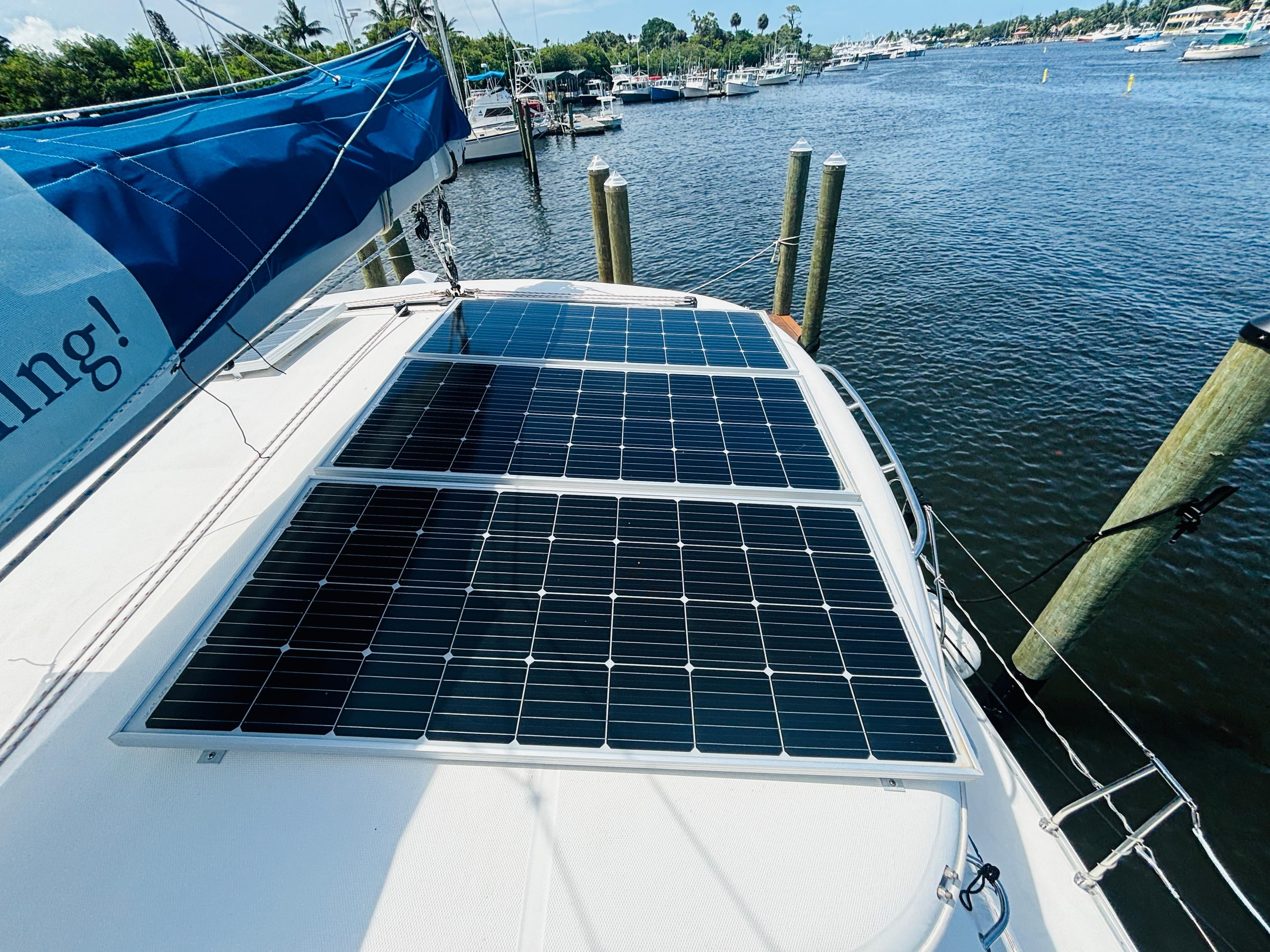 Solar panels on a 2006 Leopard 40 catamaran docked by a scenic waterfront.