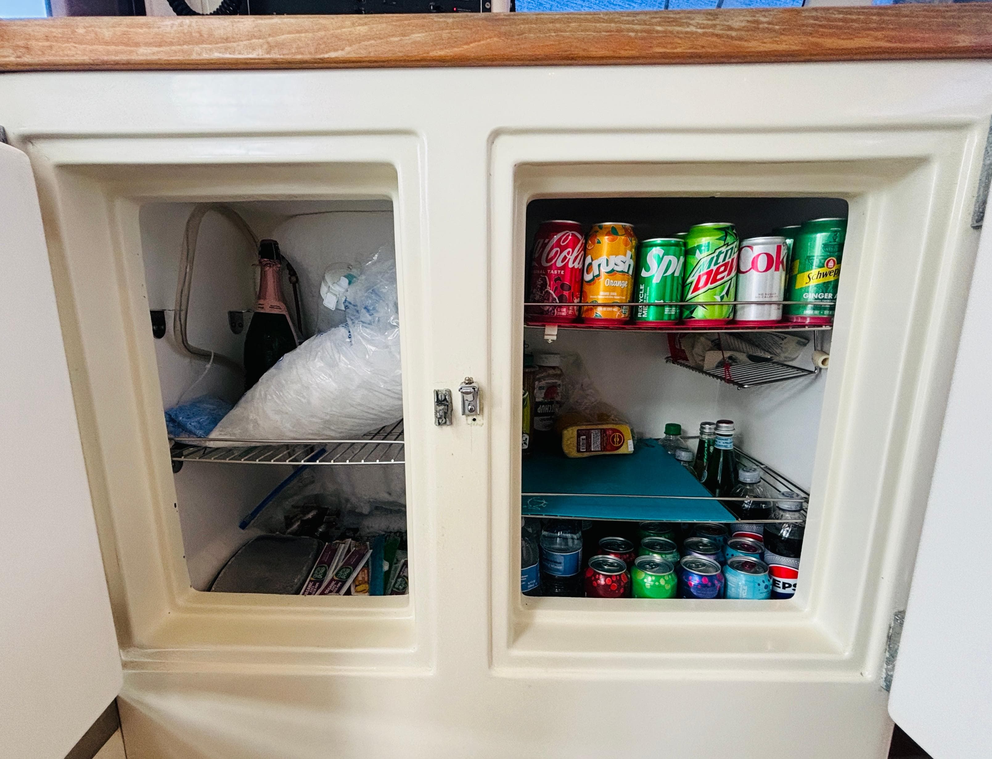 Refrigerator stocked with assorted beverages and ice, inside a 2006 Leopard 40 yacht.