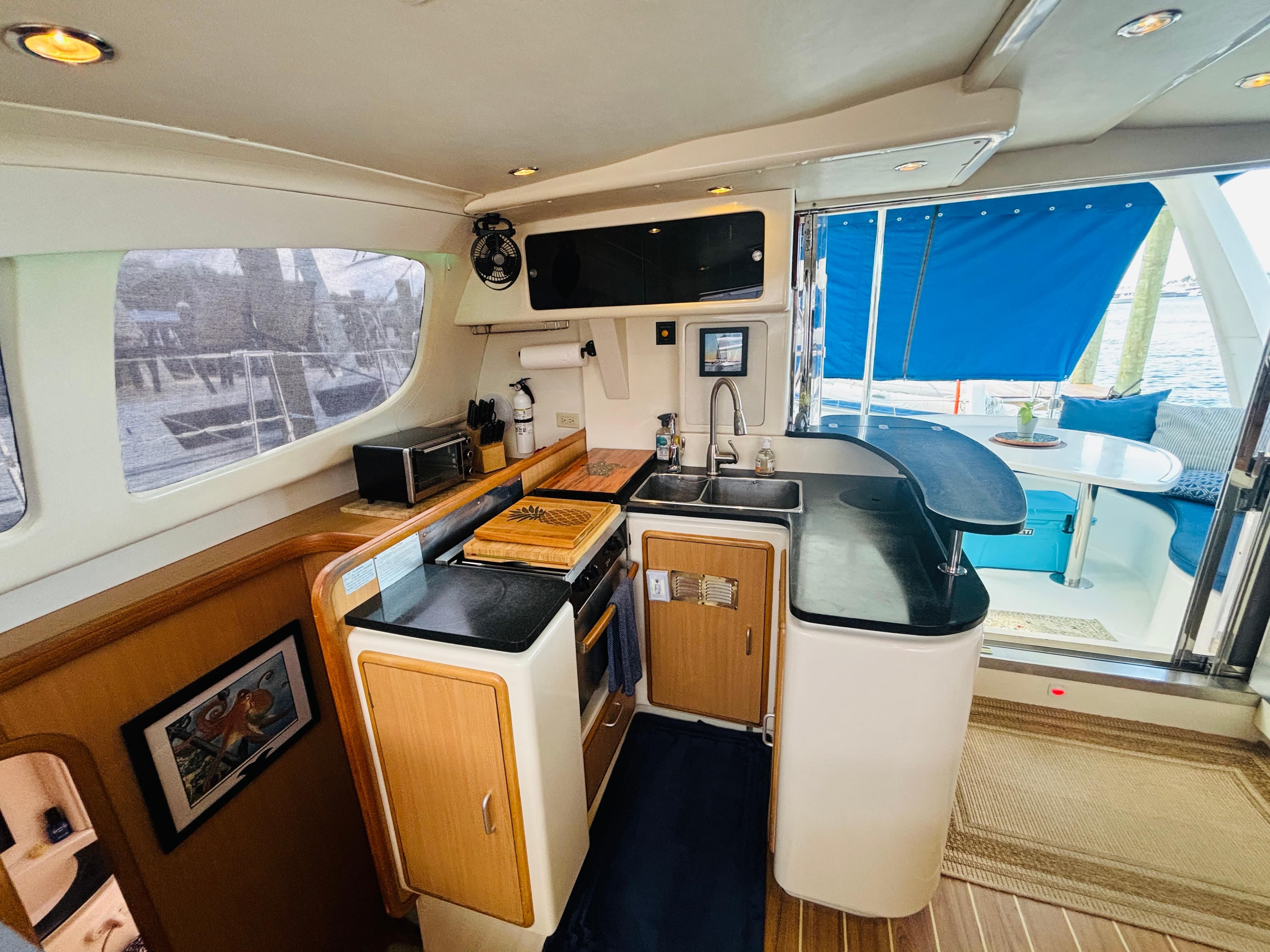 Interior of 2006 Leopard 40 catamaran kitchen with modern amenities and outdoor seating area.