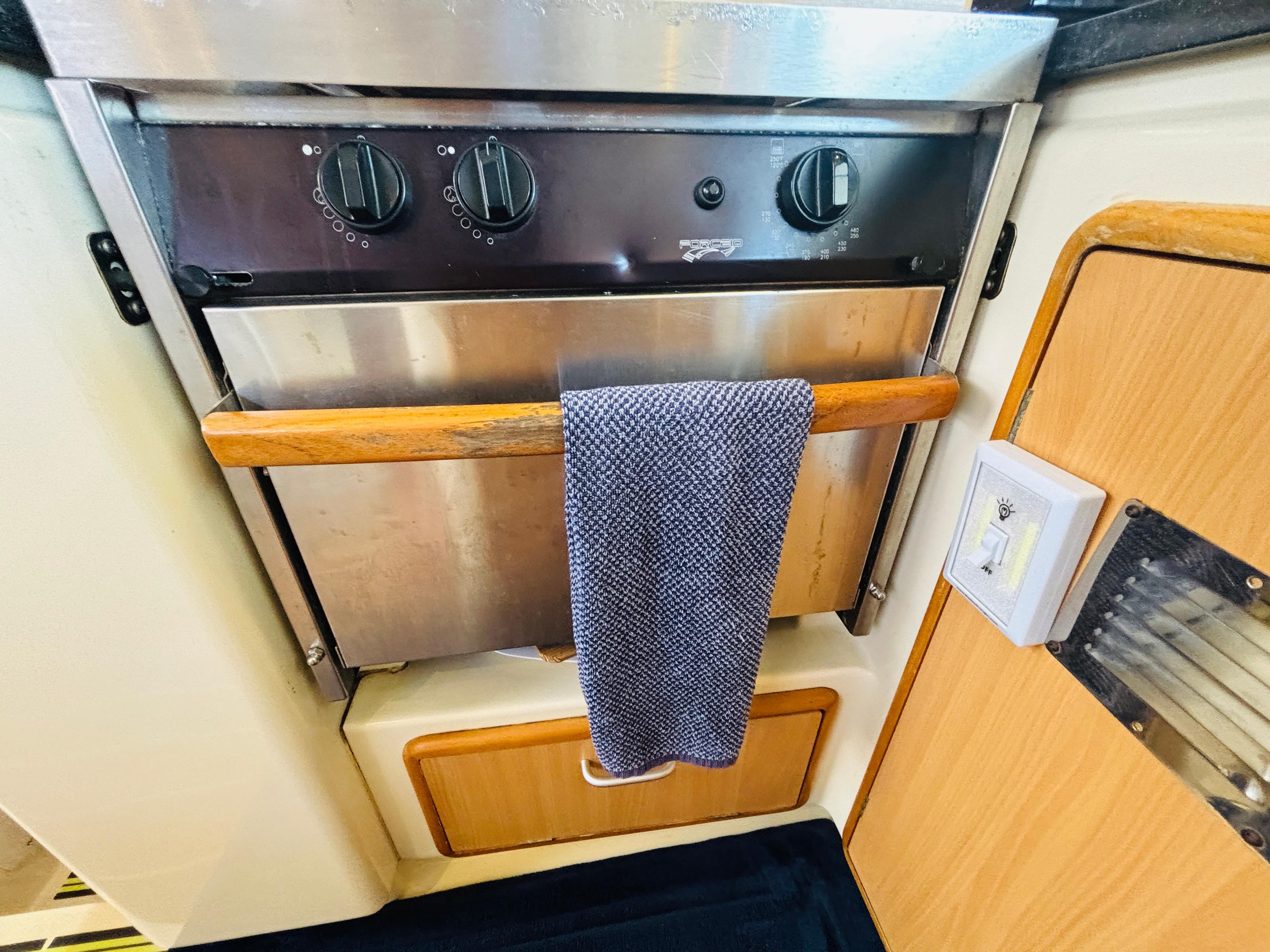 Stainless steel oven in 2006 Leopard 40 yacht kitchen with wooden accents and towel.